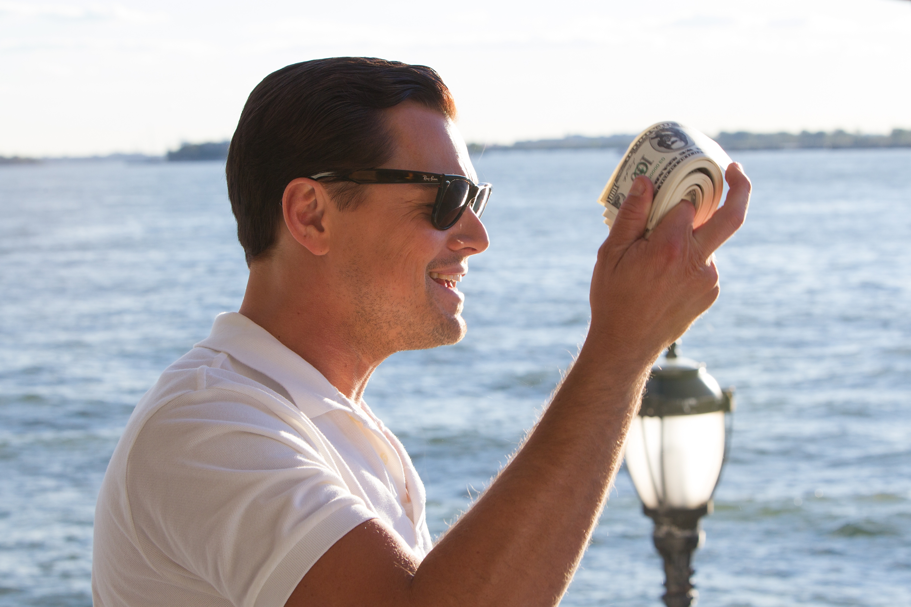 Jordan Belfort from The Wolf of Wall Street holding money HD Wallpaper
