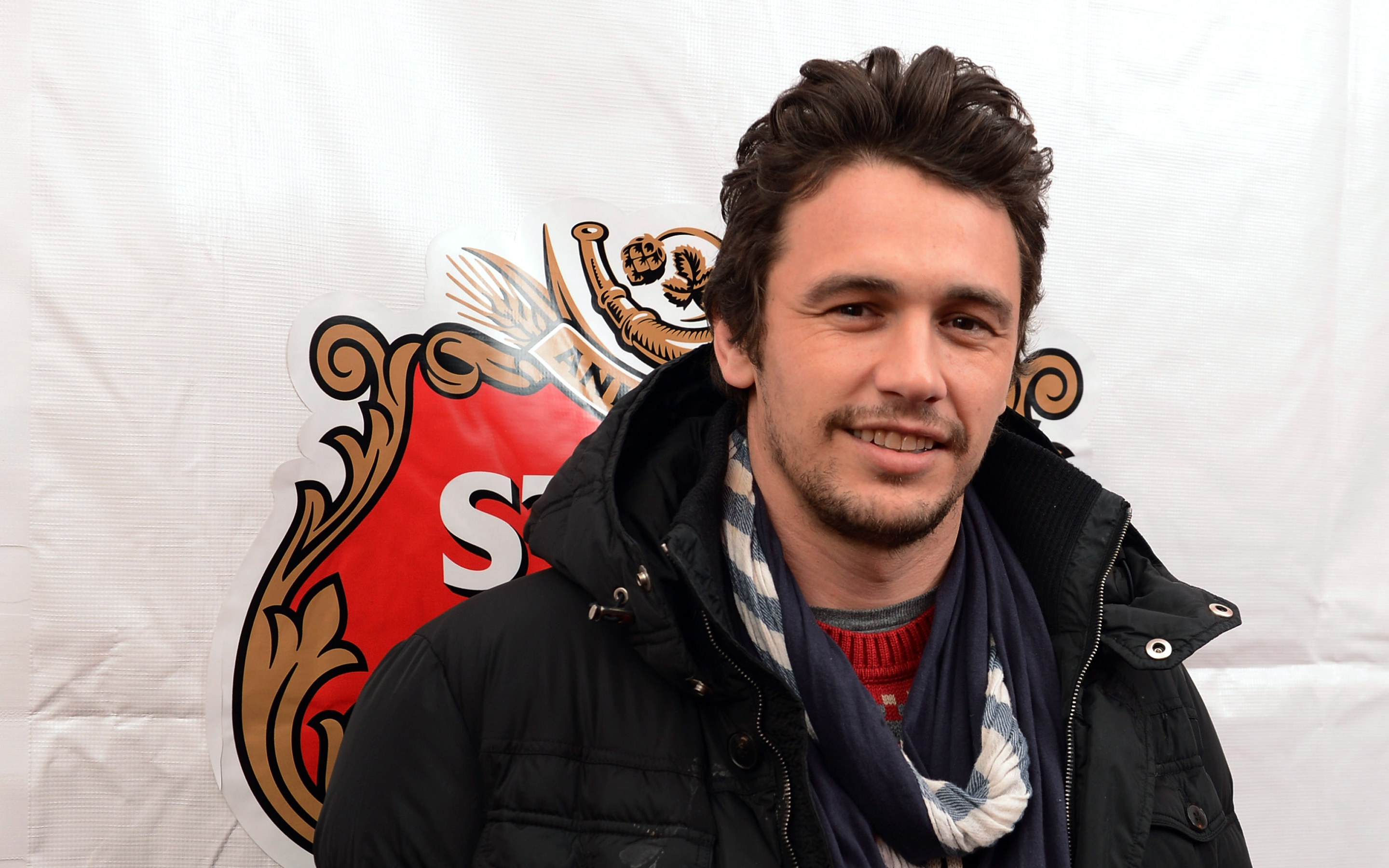James Franco in front of a logo HD Wallpaper