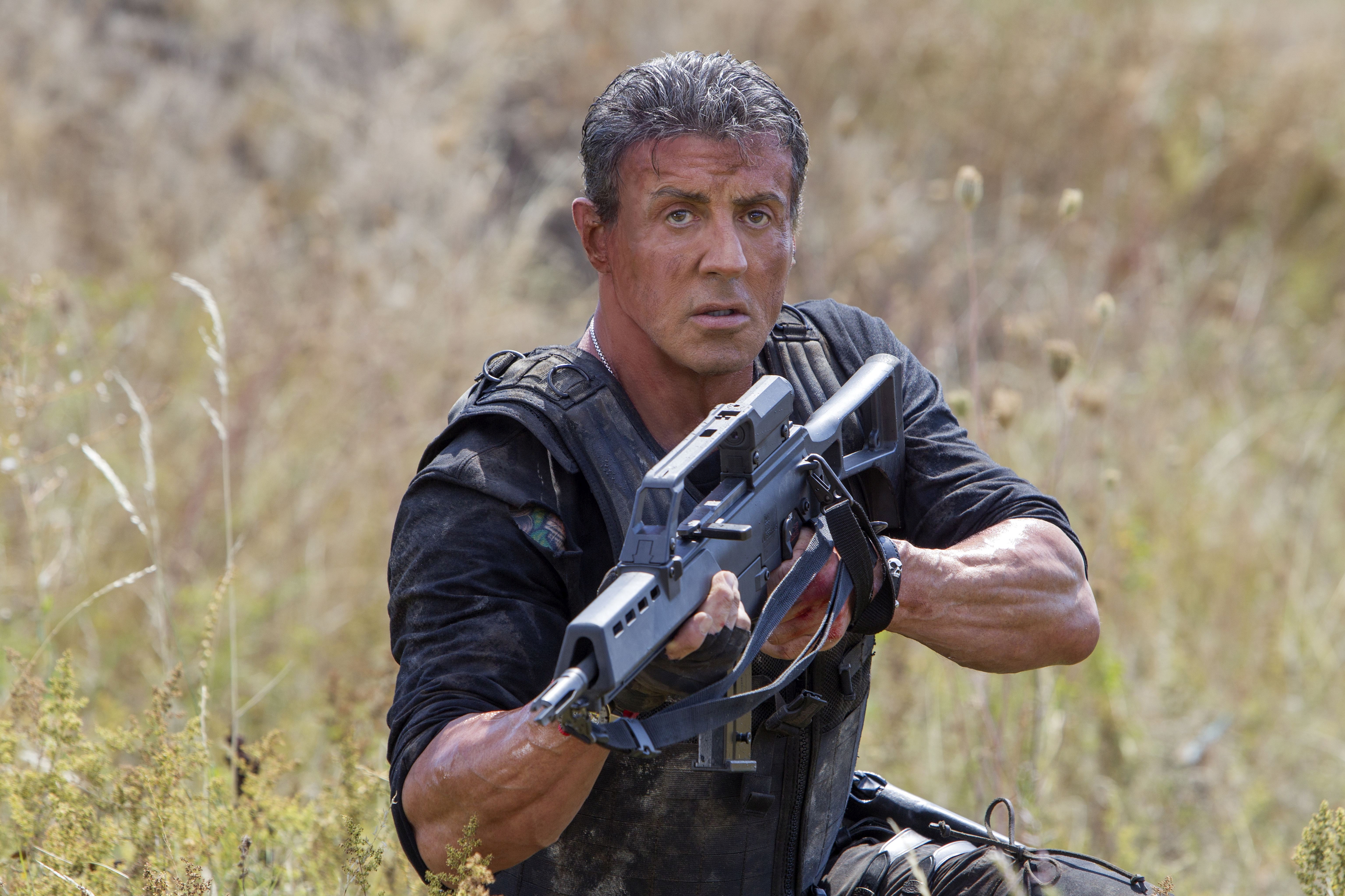 Barney Ross from The Expendables holding a rifle HD Wallpaper