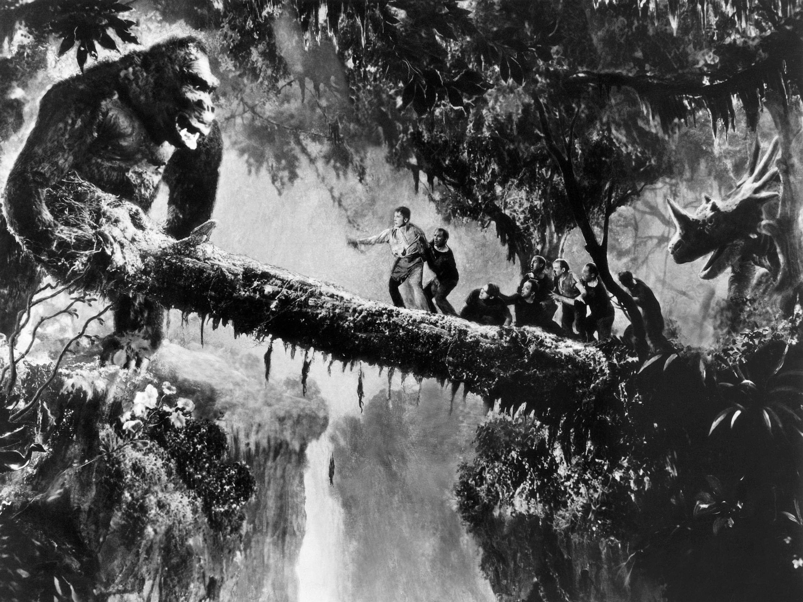 King Kong on a tree branch with people and a dinosaur HD Wallpaper