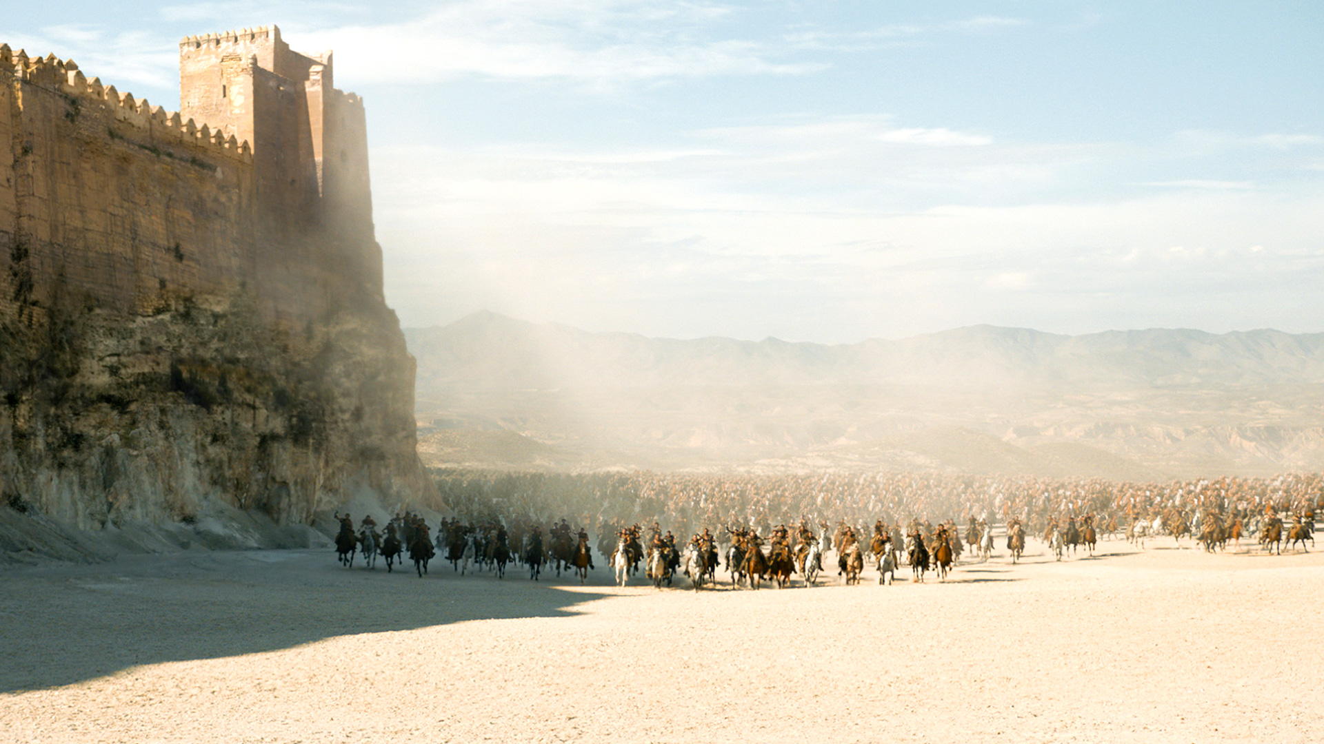 Army of horsemen approaching a fortress HD Wallpaper