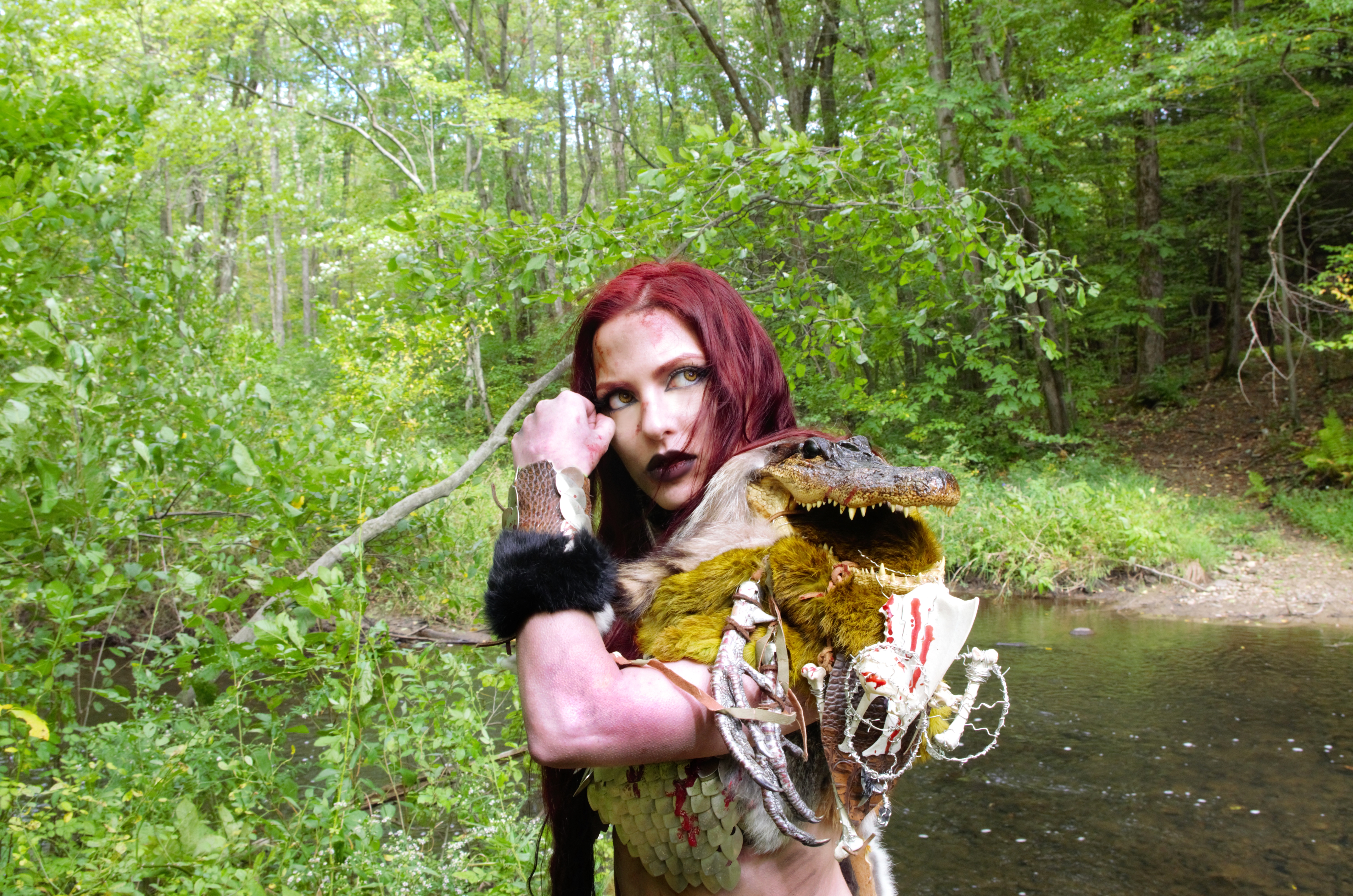 Red Sonja with alligator trophy in forest HD Wallpaper