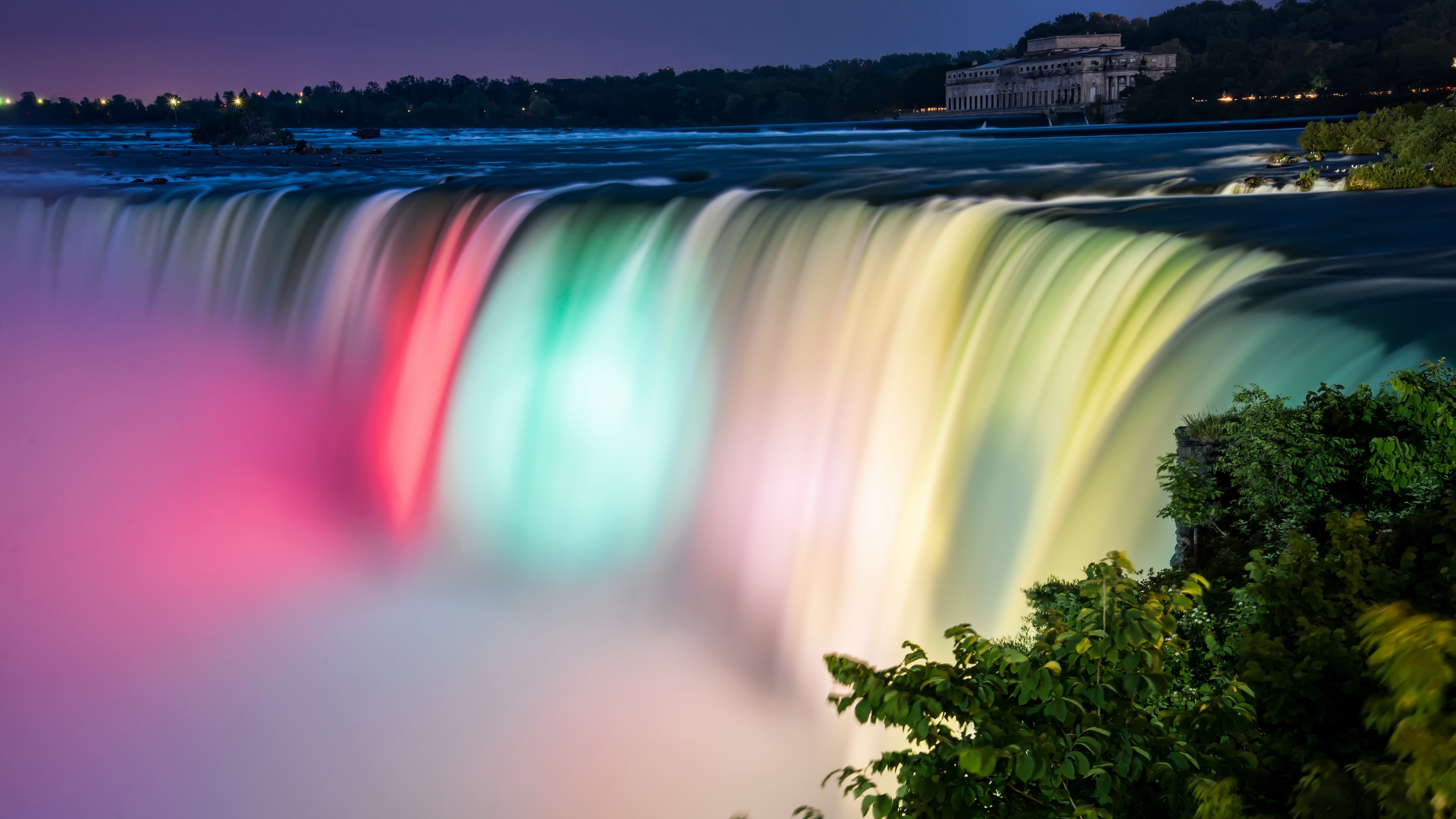 Niagara Falls illuminated with colorful lights at night HD Wallpaper
