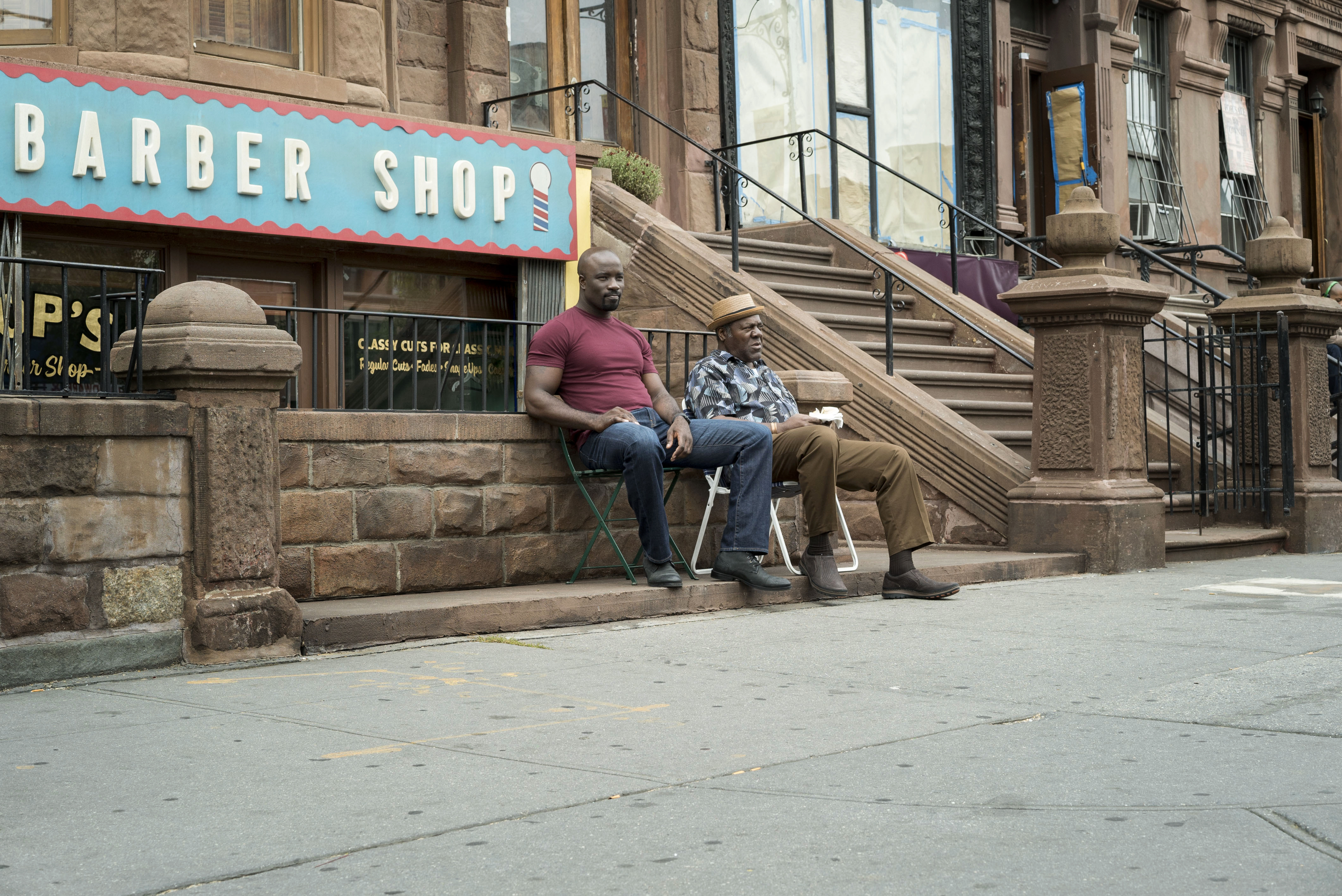 Luke Cage sitting outside a barber shop HD Wallpaper