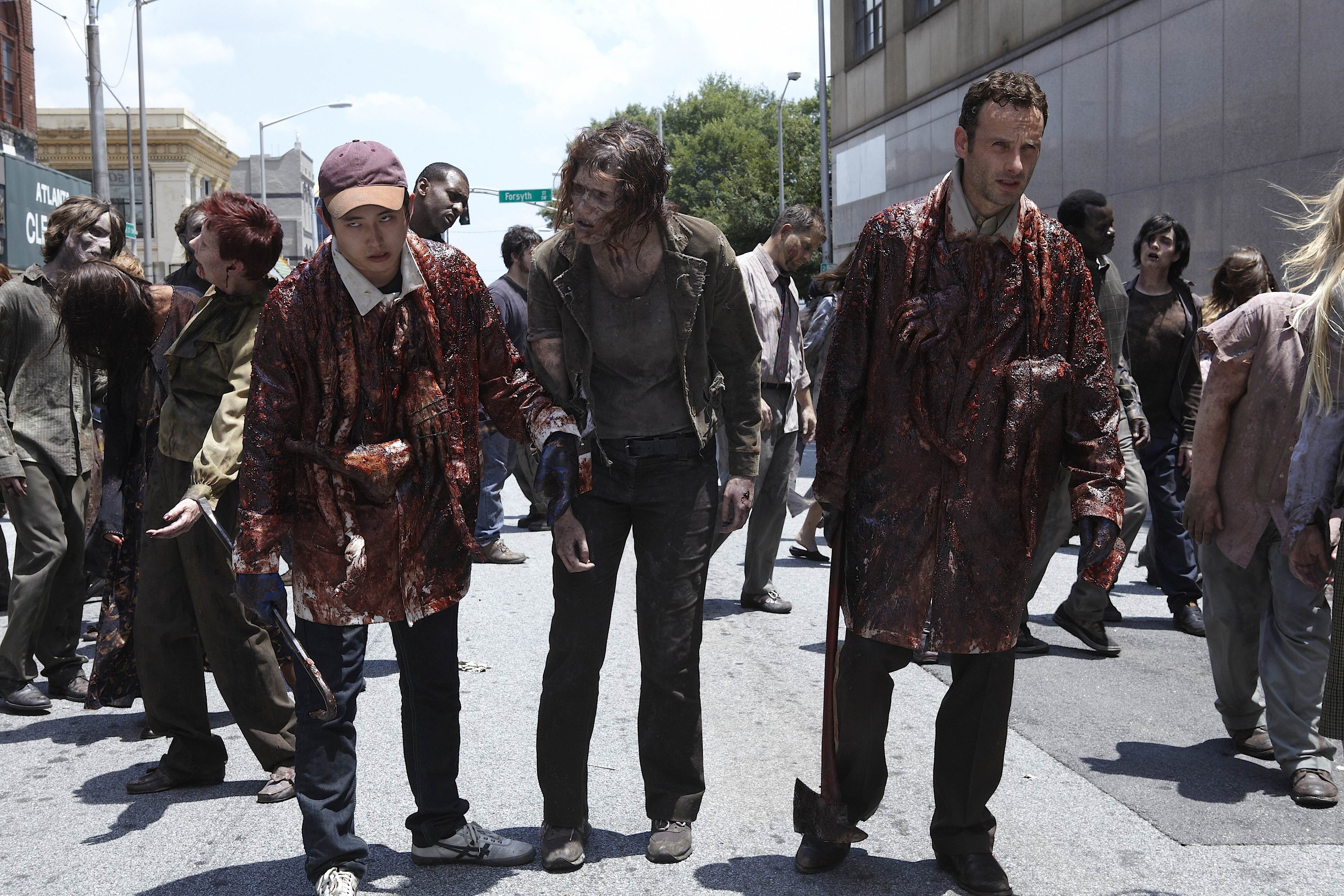 The Walking Dead: Glenn Rhee and survivors in a street HD Wallpaper