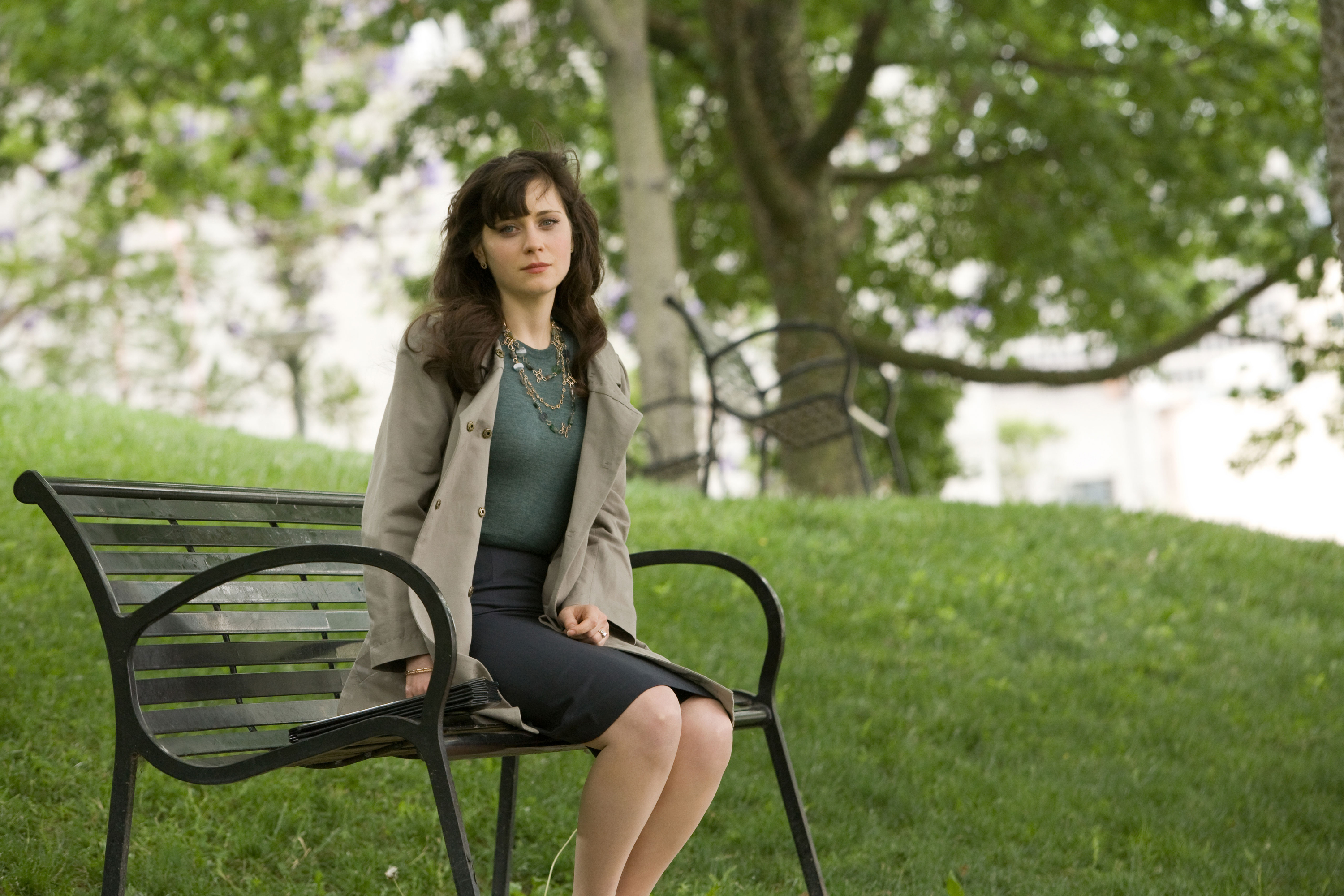 Zooey Deschanel sitting on a park bench HD Wallpaper