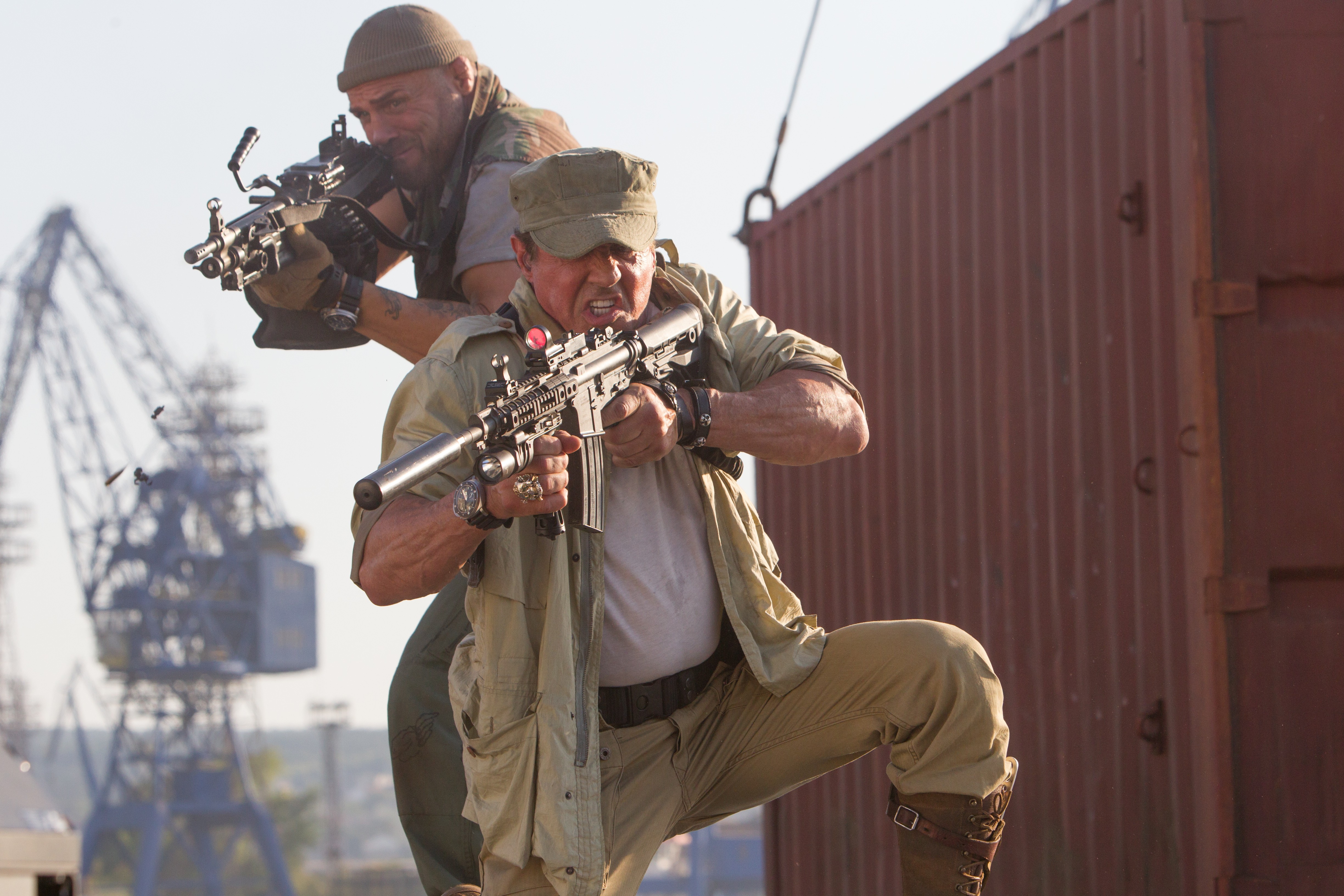 Two men with guns in a harbor HD Wallpaper