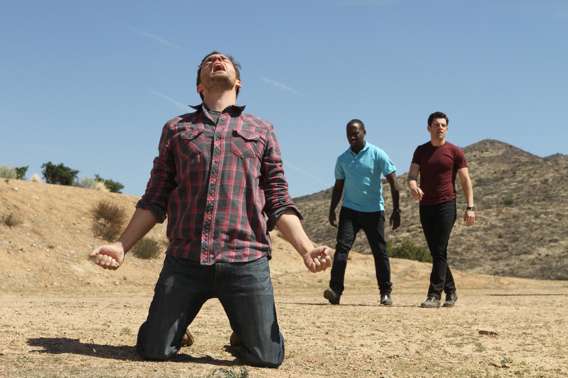 Man kneeling in desert with two men behind him HD Wallpaper