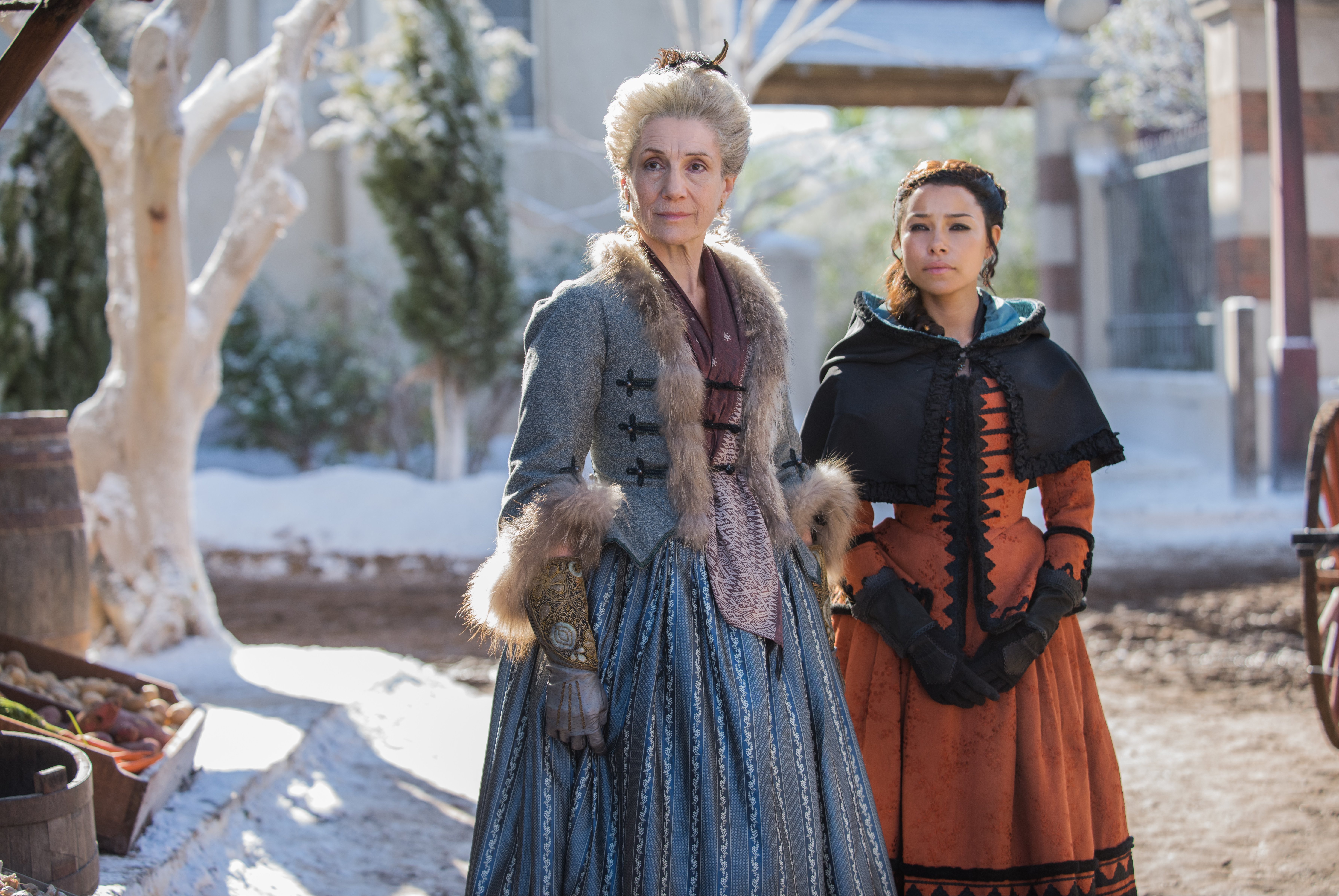 Two women in historical costumes in a snowy outdoor setting HD Wallpaper
