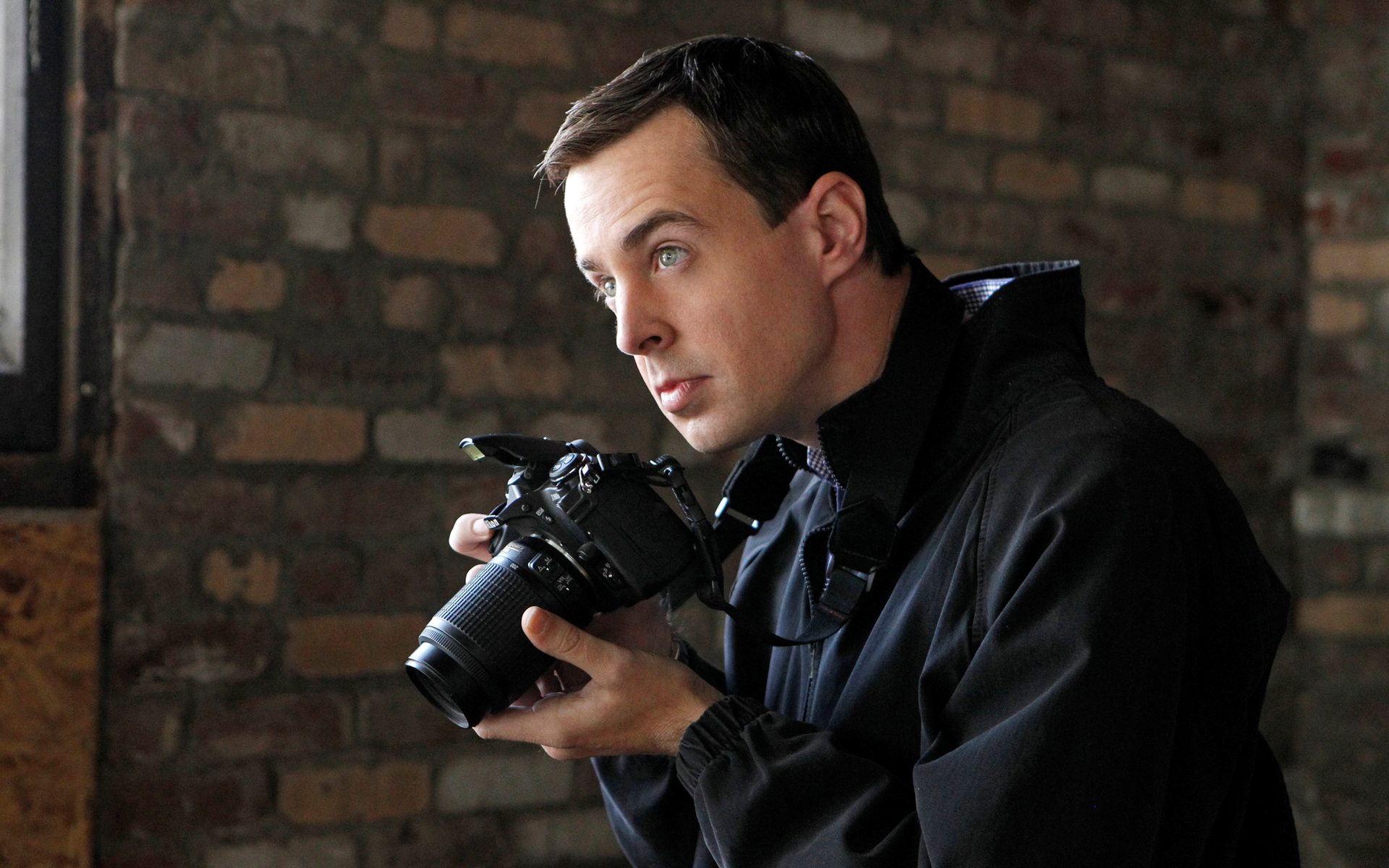 Man holding a DSLR camera HD Wallpaper