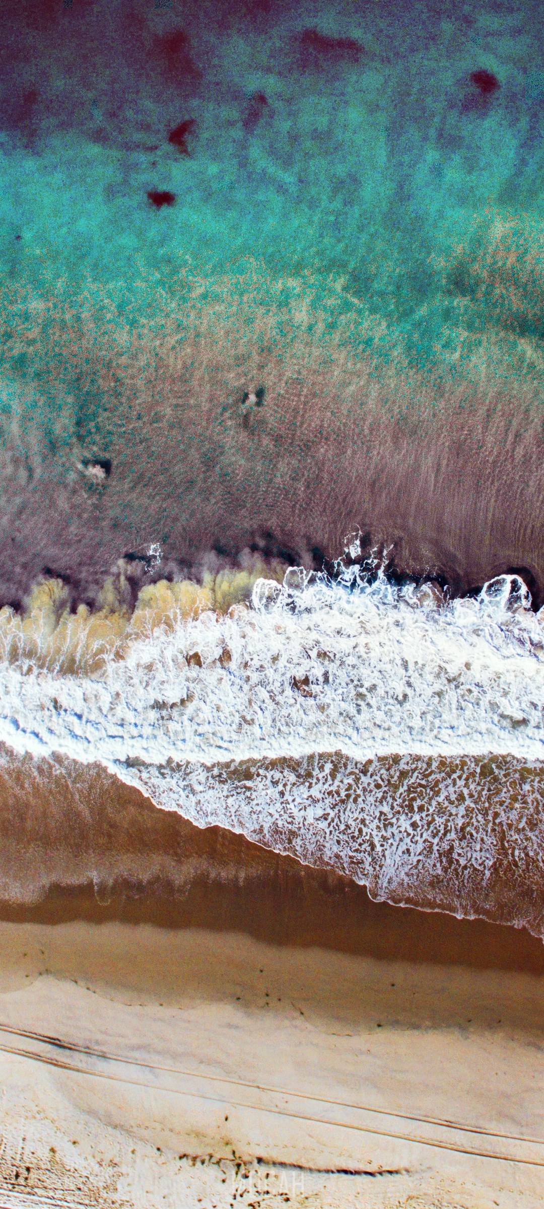 Drone view of ocean waves crashing on a sandy beach HD Phone Wallpaper