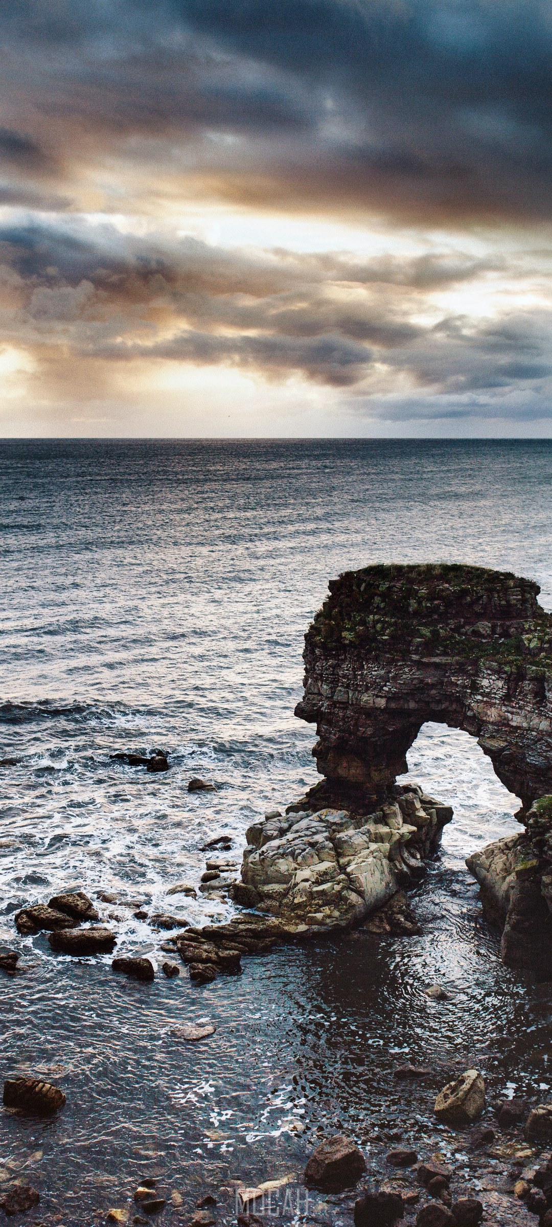 Rocky Archway in the Ocean Under Cloudy Sky HD Phone Wallpaper