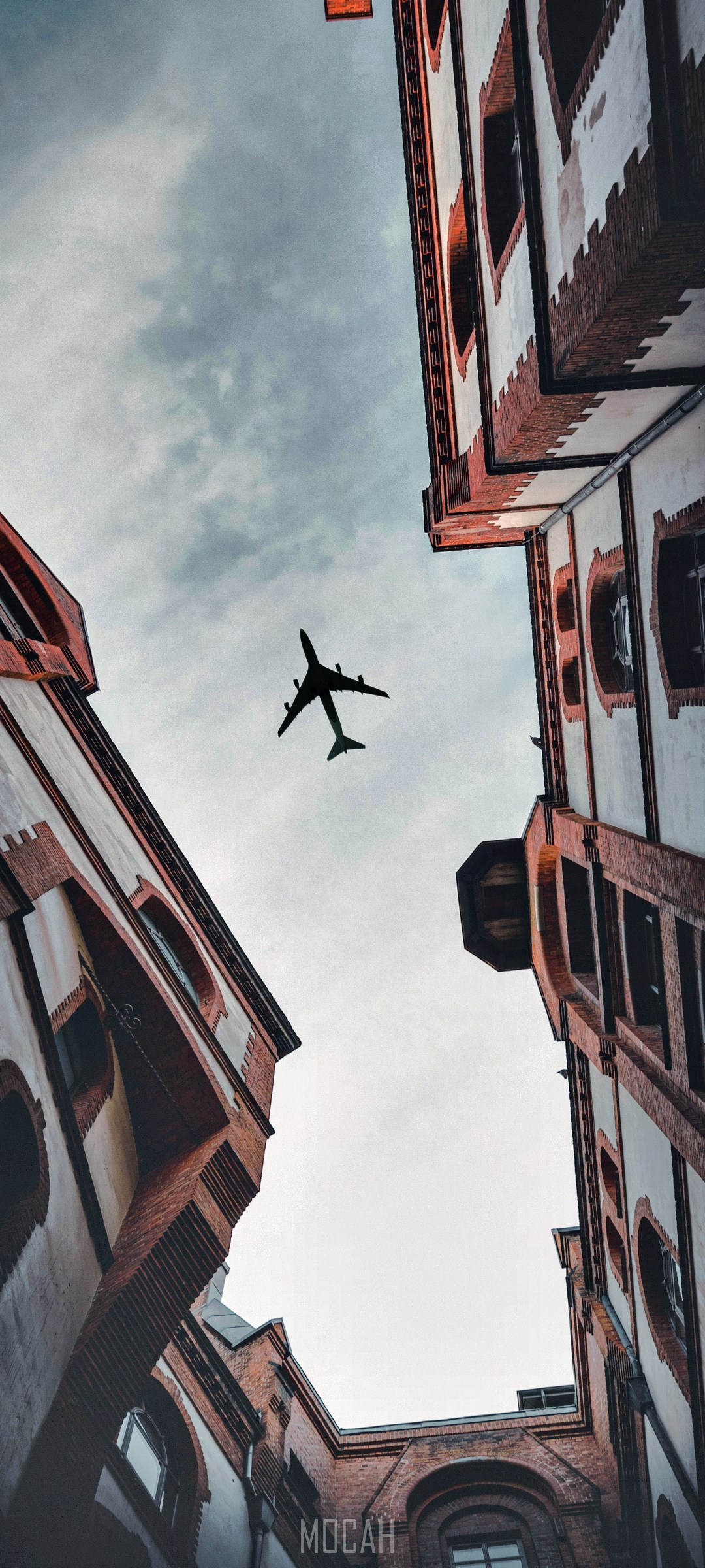 Airplane flying between buildings HD Phone Wallpaper