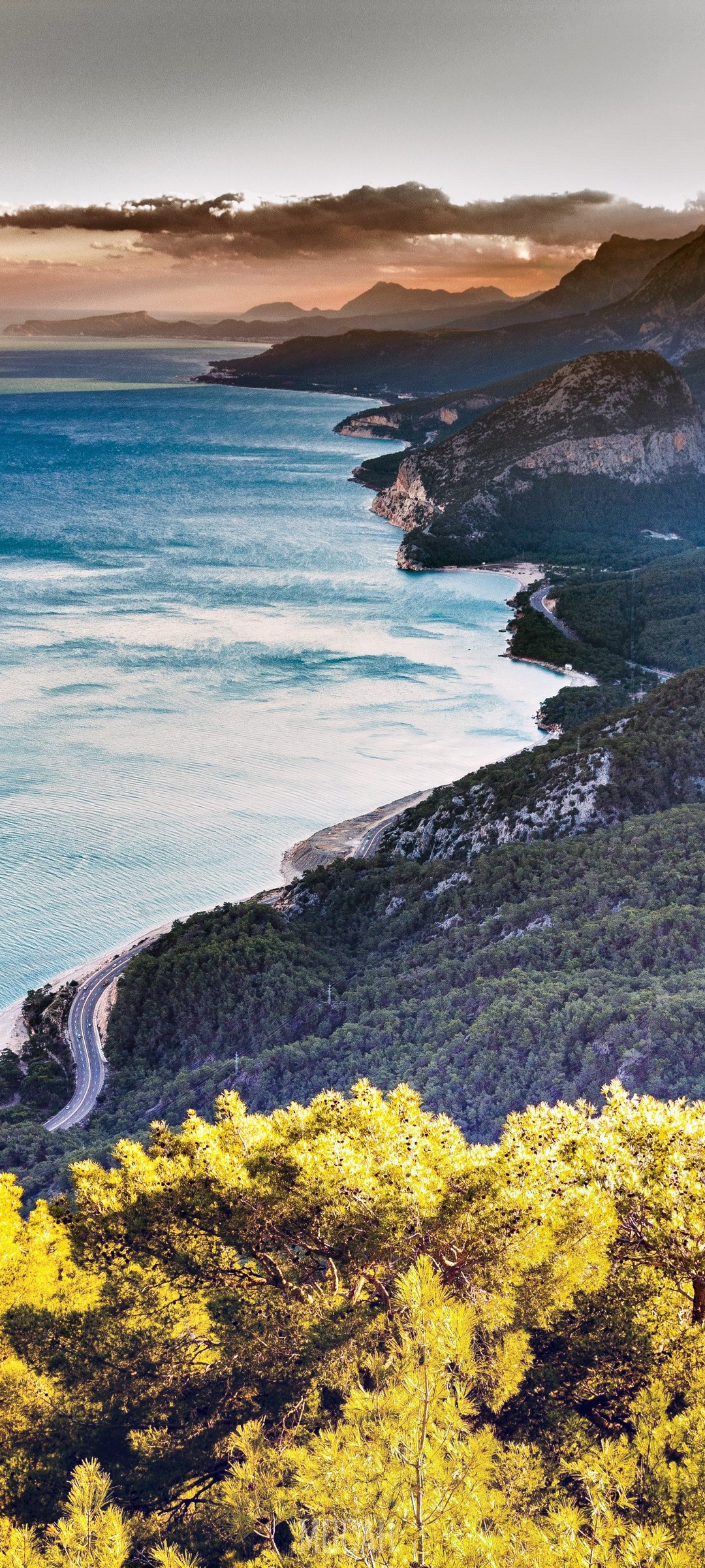 Hilly green shoreline with winding road at Antalya HD Phone Wallpaper