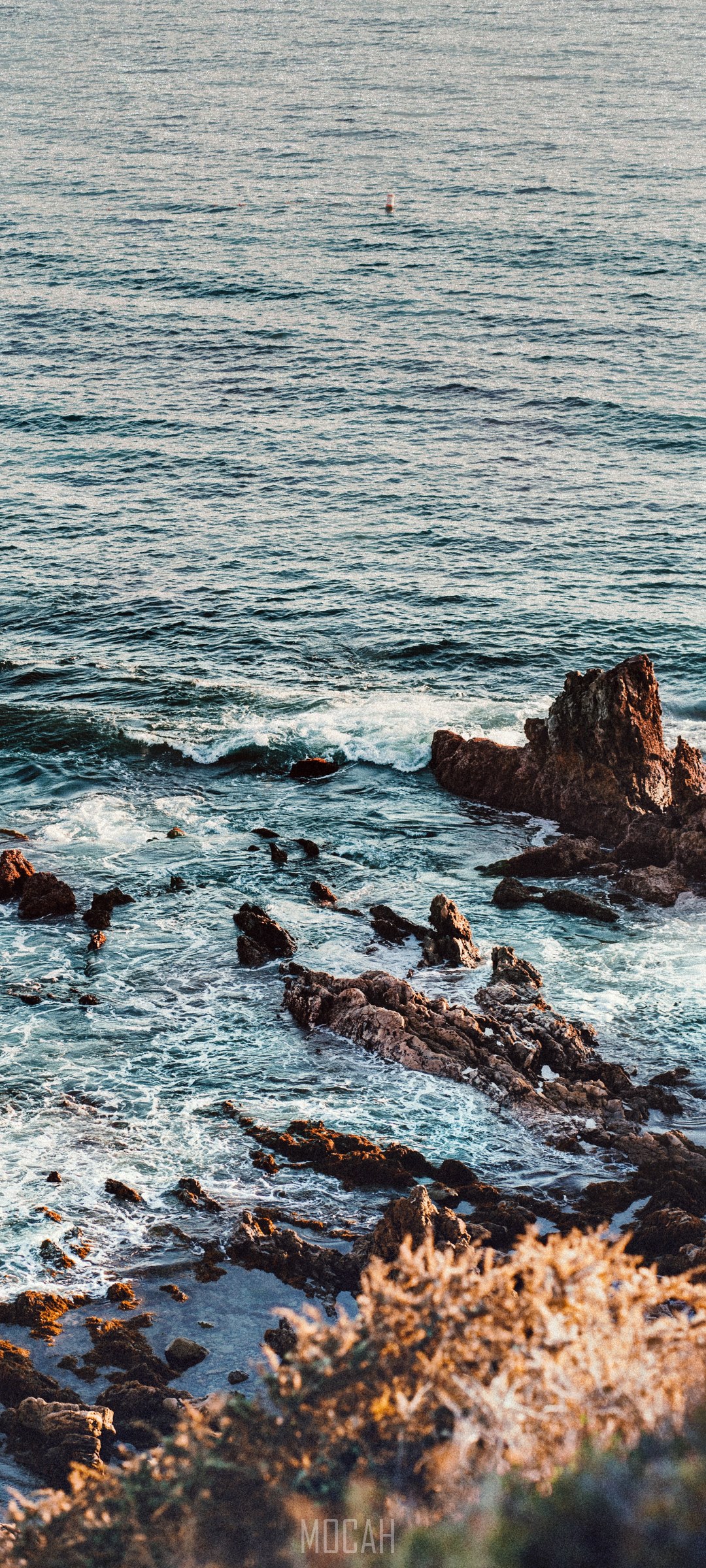 Ocean waves crashing on rocky shore with a buoy HD Phone Wallpaper