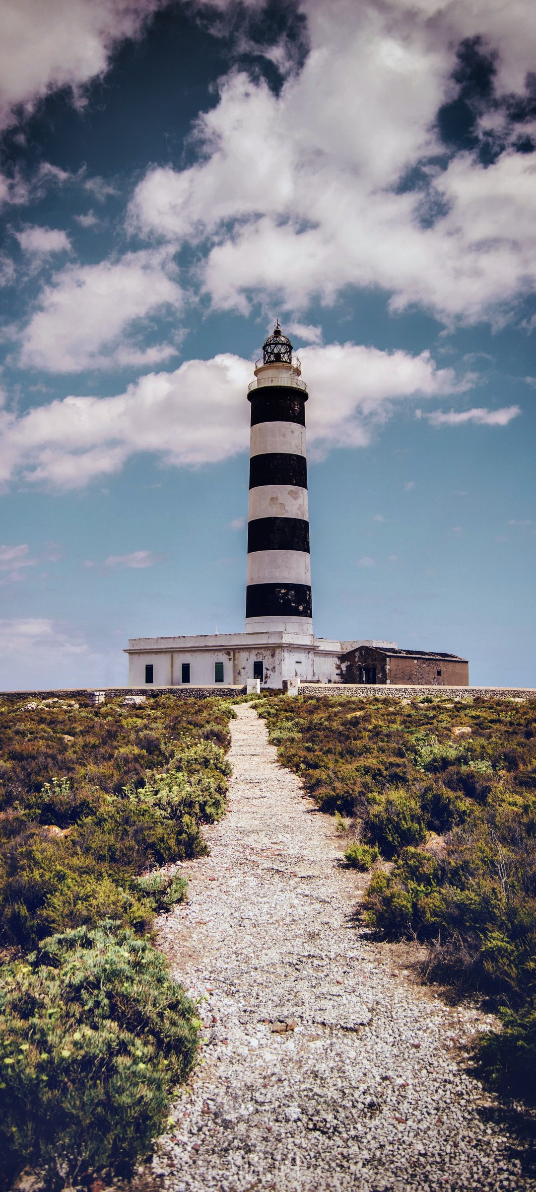 Black and white striped lighthouse on a grassy hill HD Phone Wallpaper