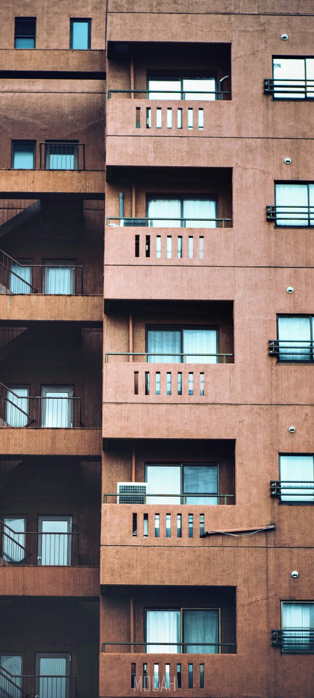 Facade of a brown apartment building with balconies and windows HD Phone Wallpaper