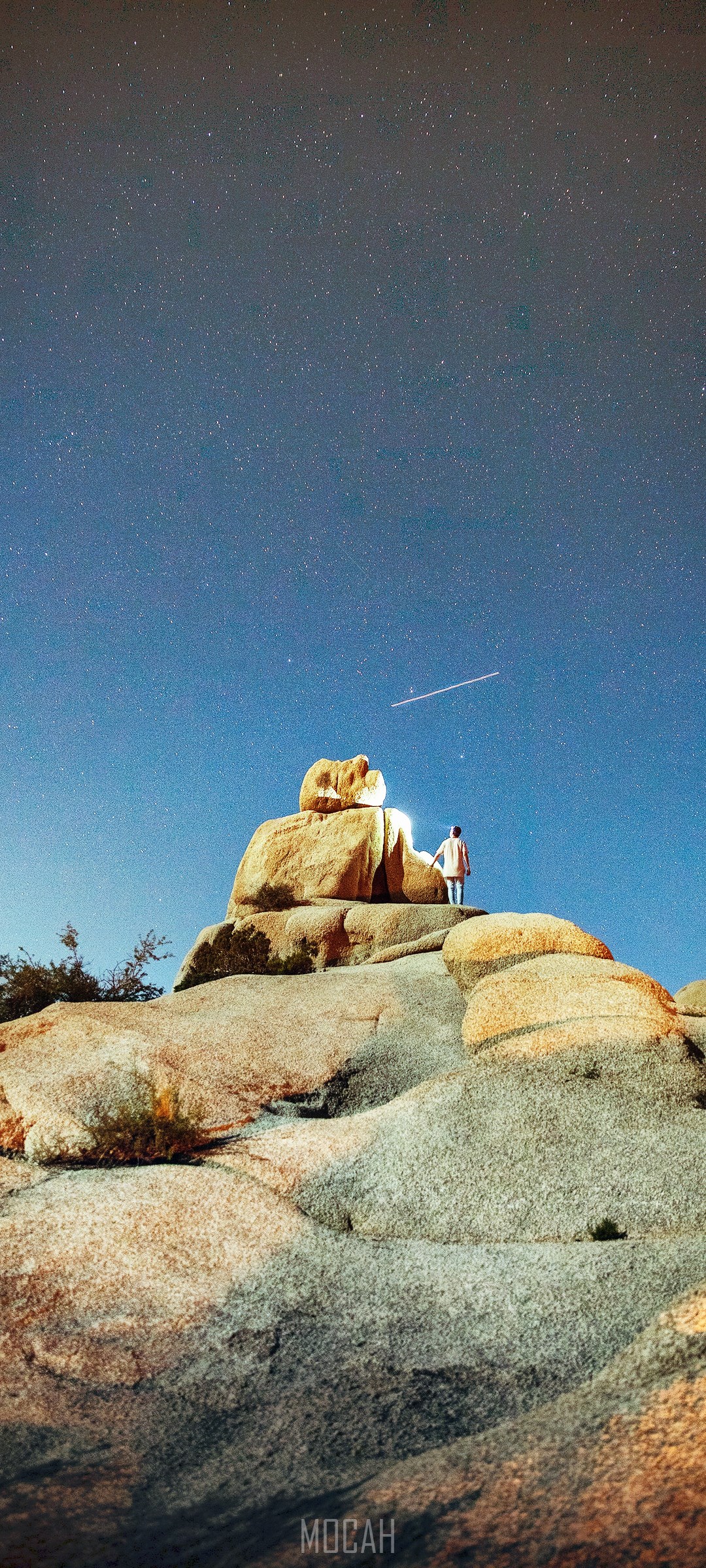 Person standing on rocks under starry night sky HD Phone Wallpaper