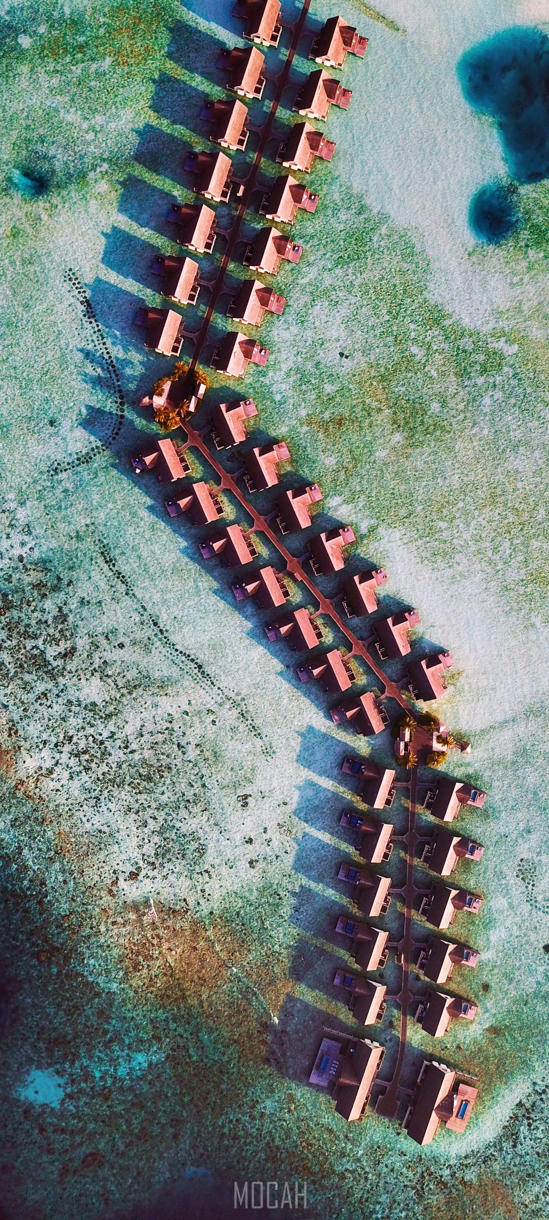 Aerial view of overwater bungalows in turquoise water HD Phone Wallpaper