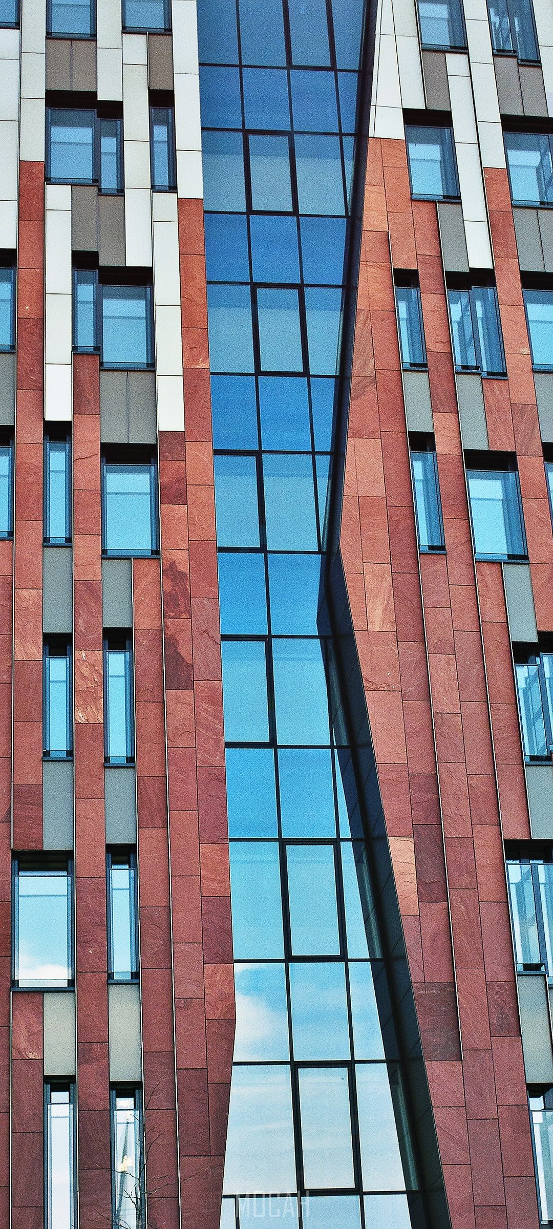 Modern building facade with red stone and blue glass windows HD Phone Wallpaper