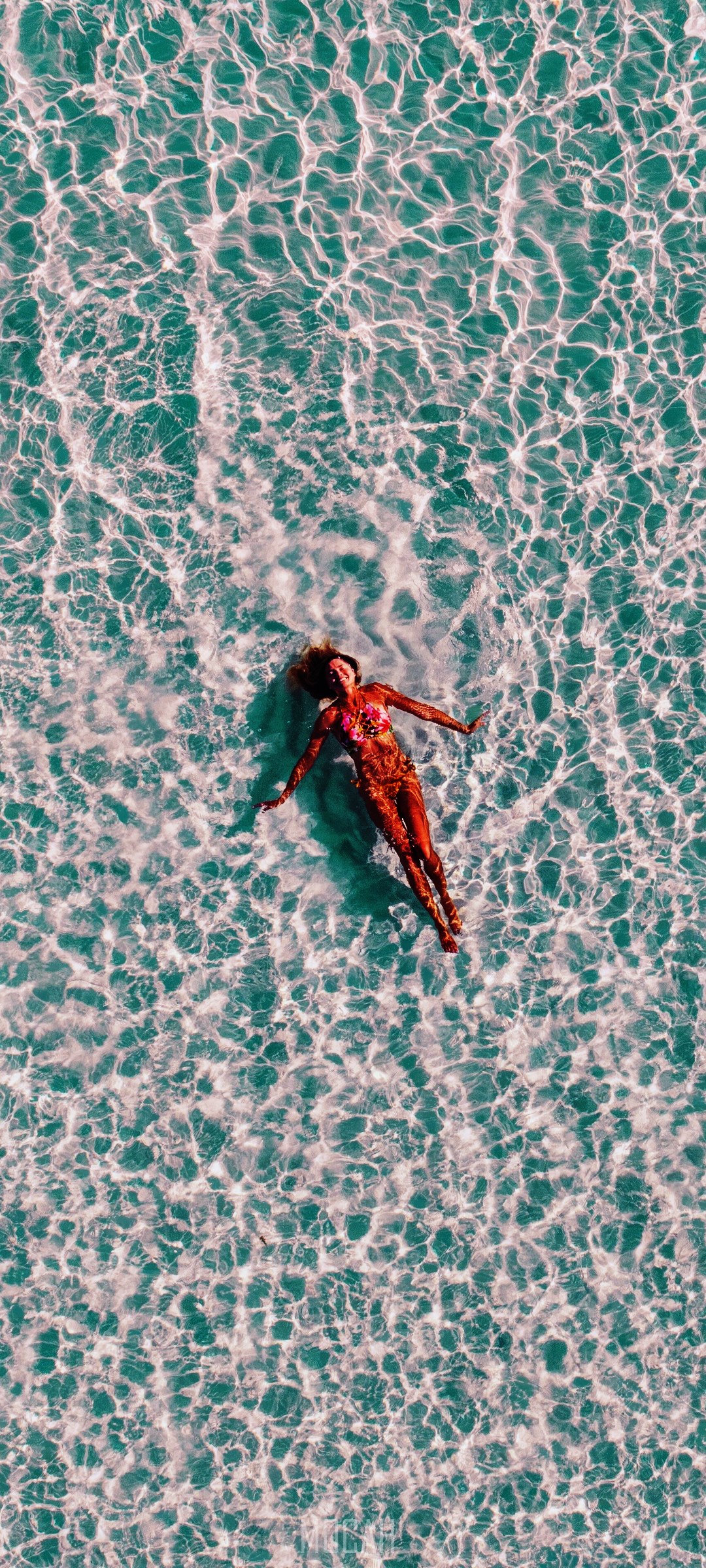 Woman in bikini floating on back in clear ocean water HD Phone Wallpaper