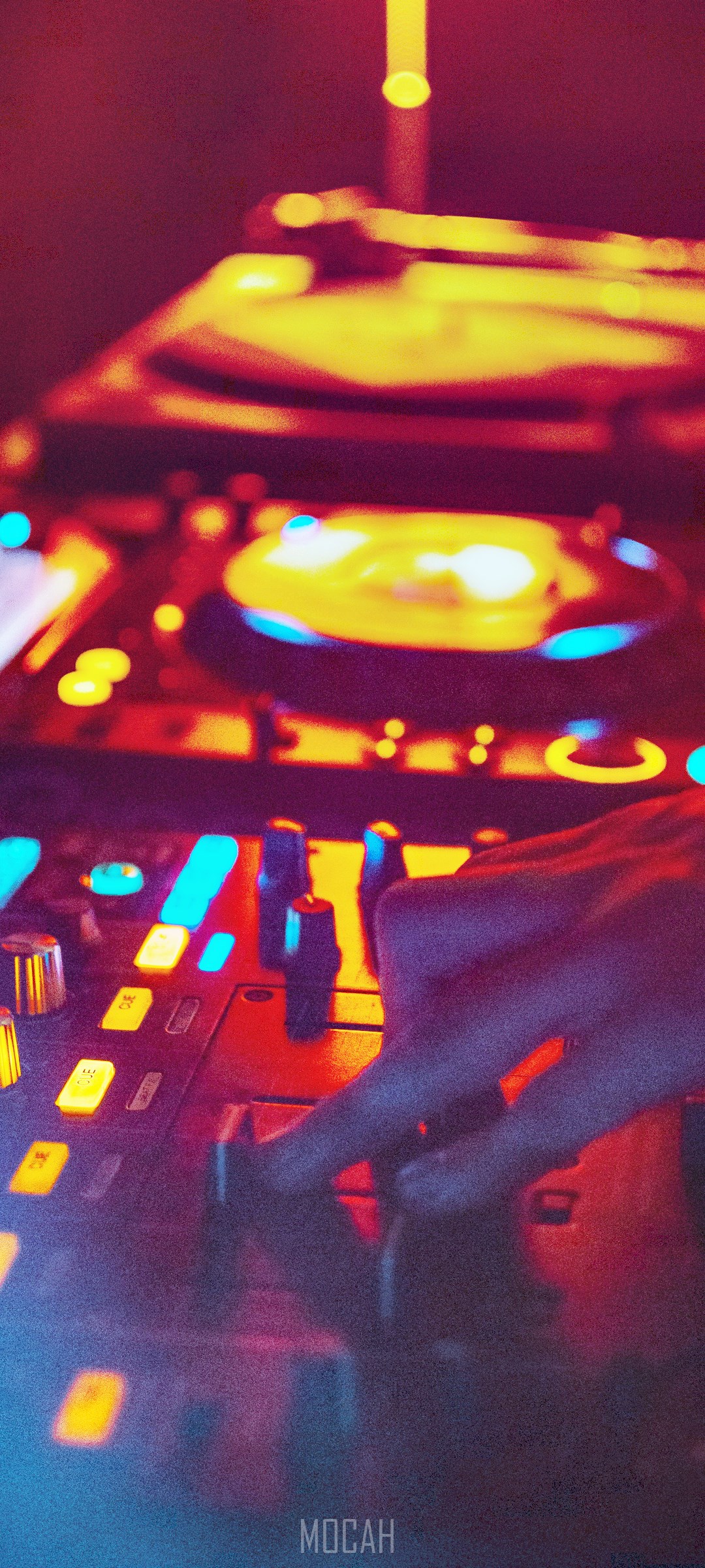 DJ mixing music on a console with colorful lights HD Phone Wallpaper
