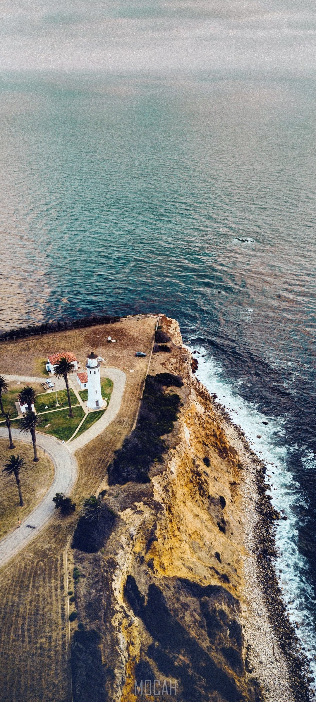 Lighthouse on a cliff overlooking the ocean HD Phone Wallpaper