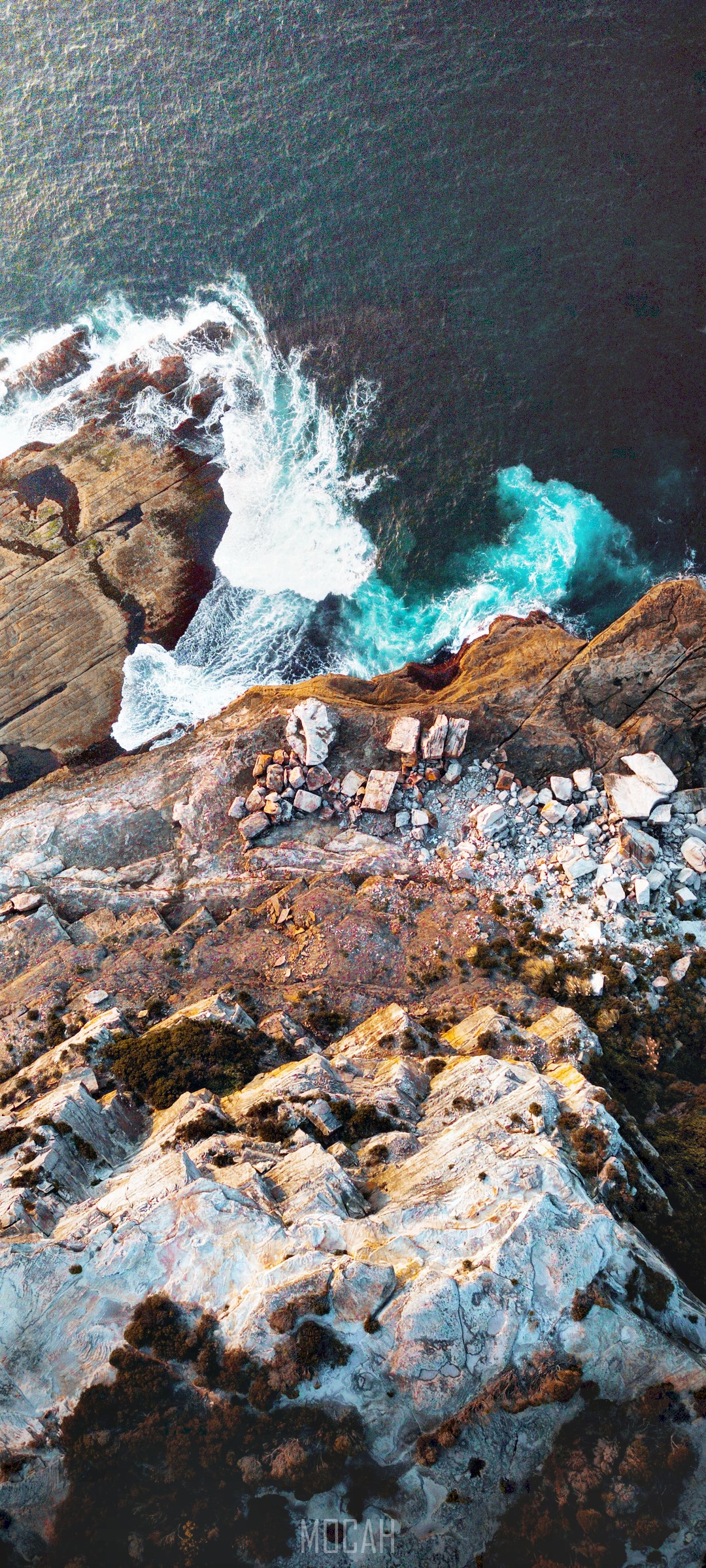 Aerial view of rocky coastline with crashing waves HD Phone Wallpaper