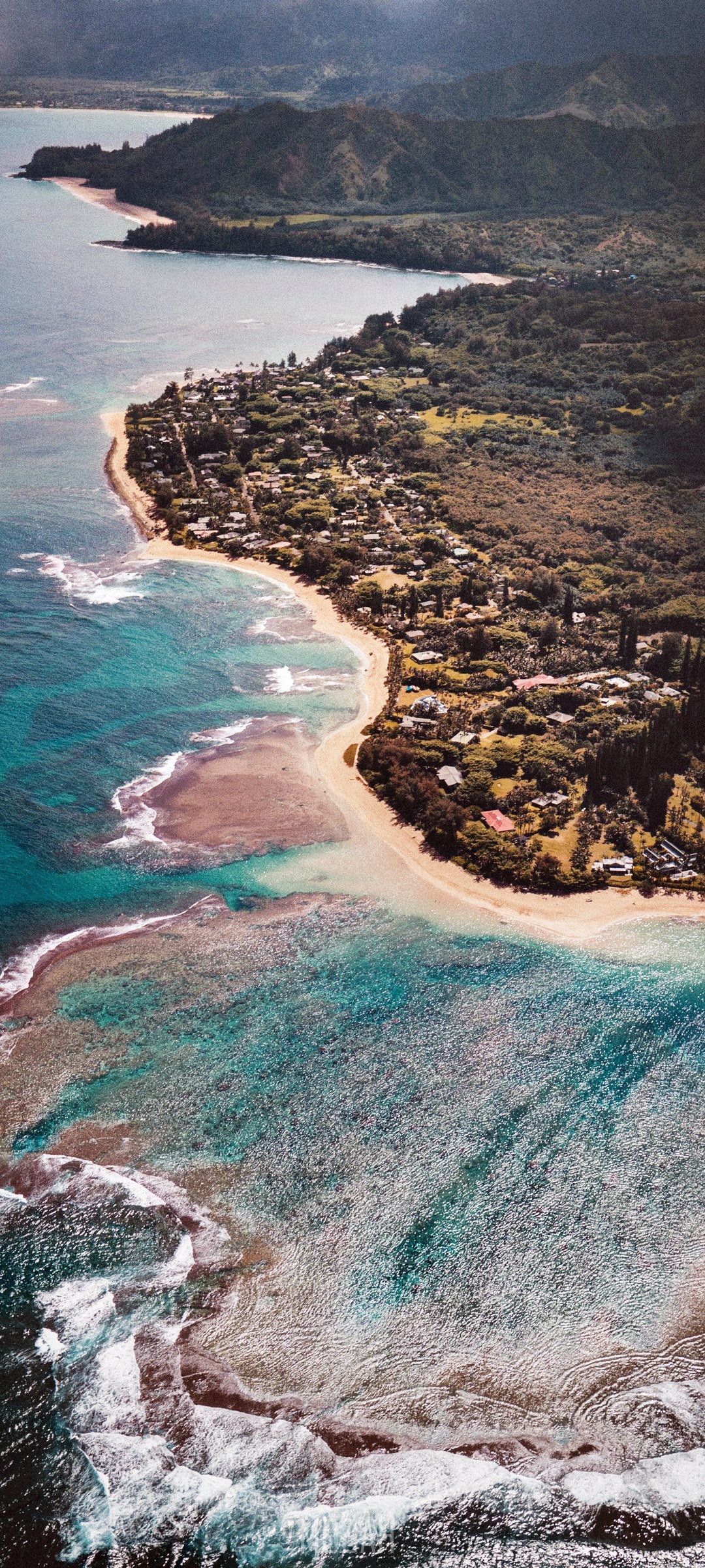 Aerial view of Kauai coast with turquoise waters and lush green hills HD Phone Wallpaper