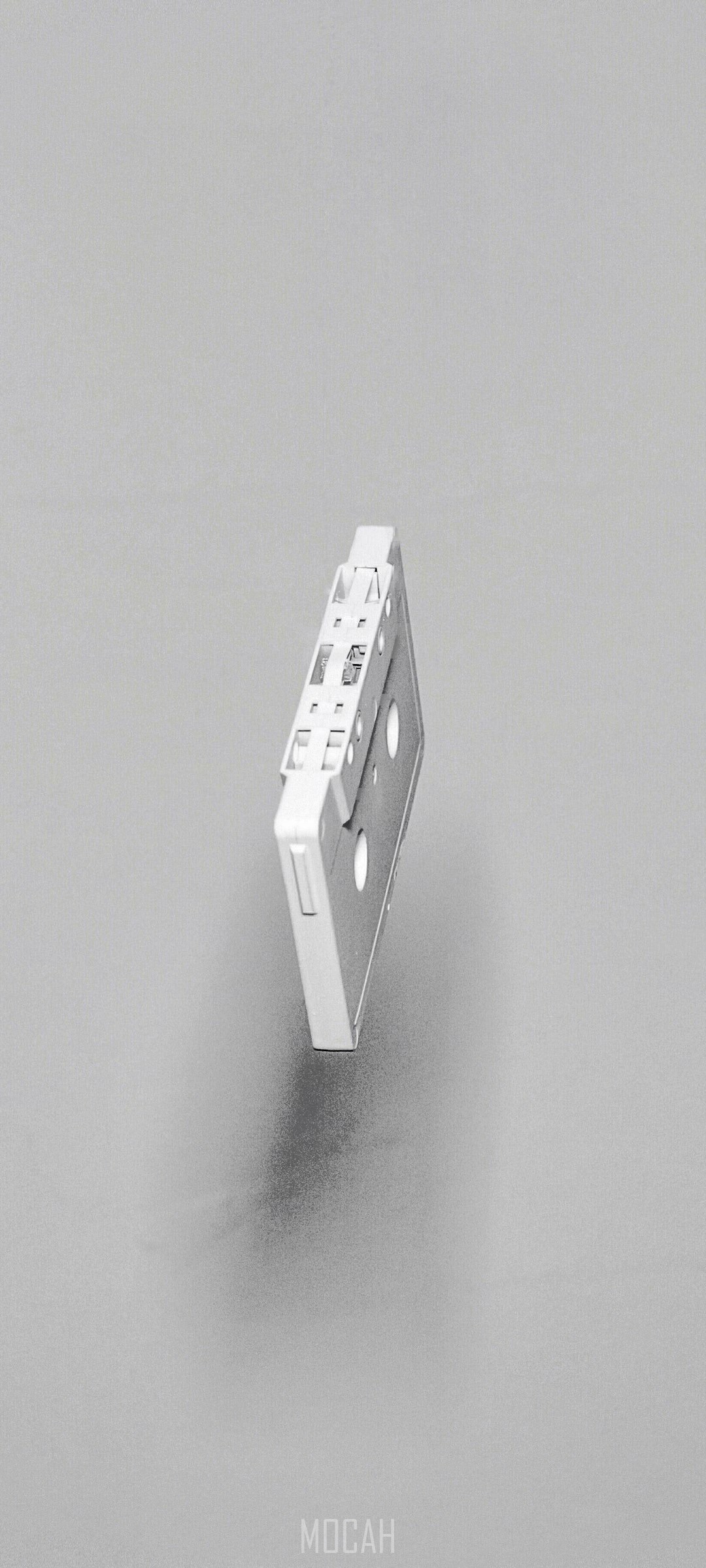 A white cassette tape suspended in the air HD Phone Wallpaper