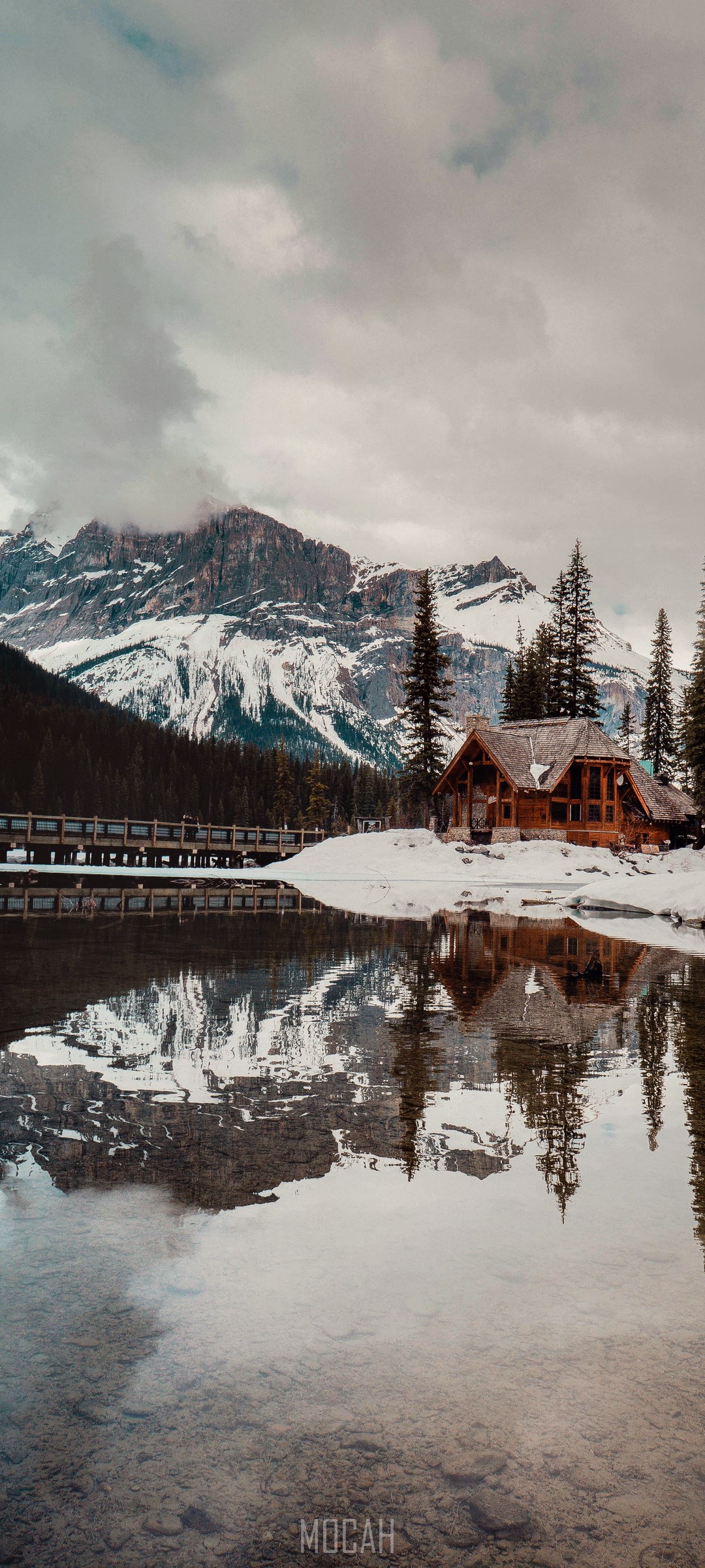 Wooden cabin by a snowy lake with mountains and reflection HD Phone Wallpaper
