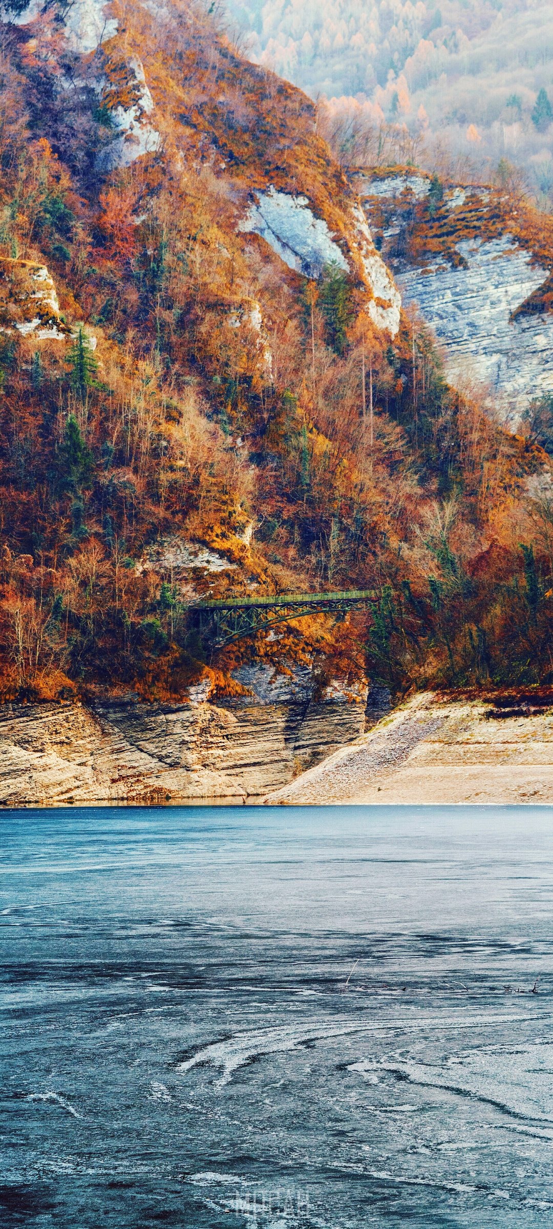 Mountains with autumn trees by a frozen lake HD Phone Wallpaper