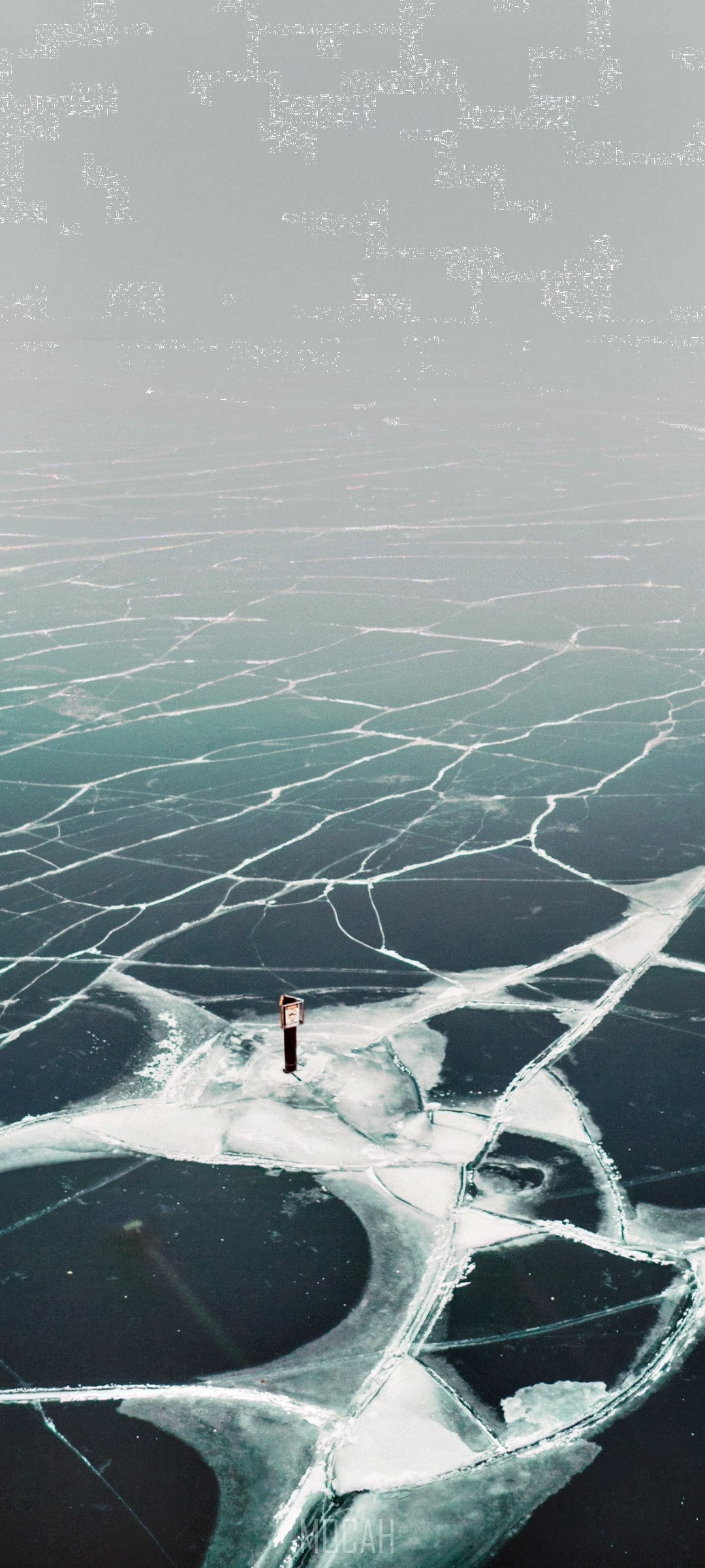 Cracked ice on a lake with a small structure HD Phone Wallpaper