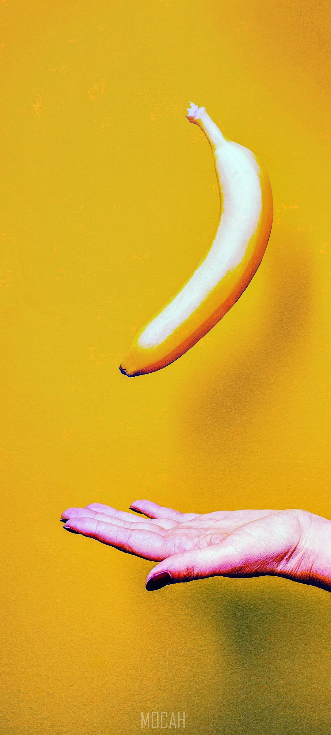 Banana floating above a hand HD Phone Wallpaper