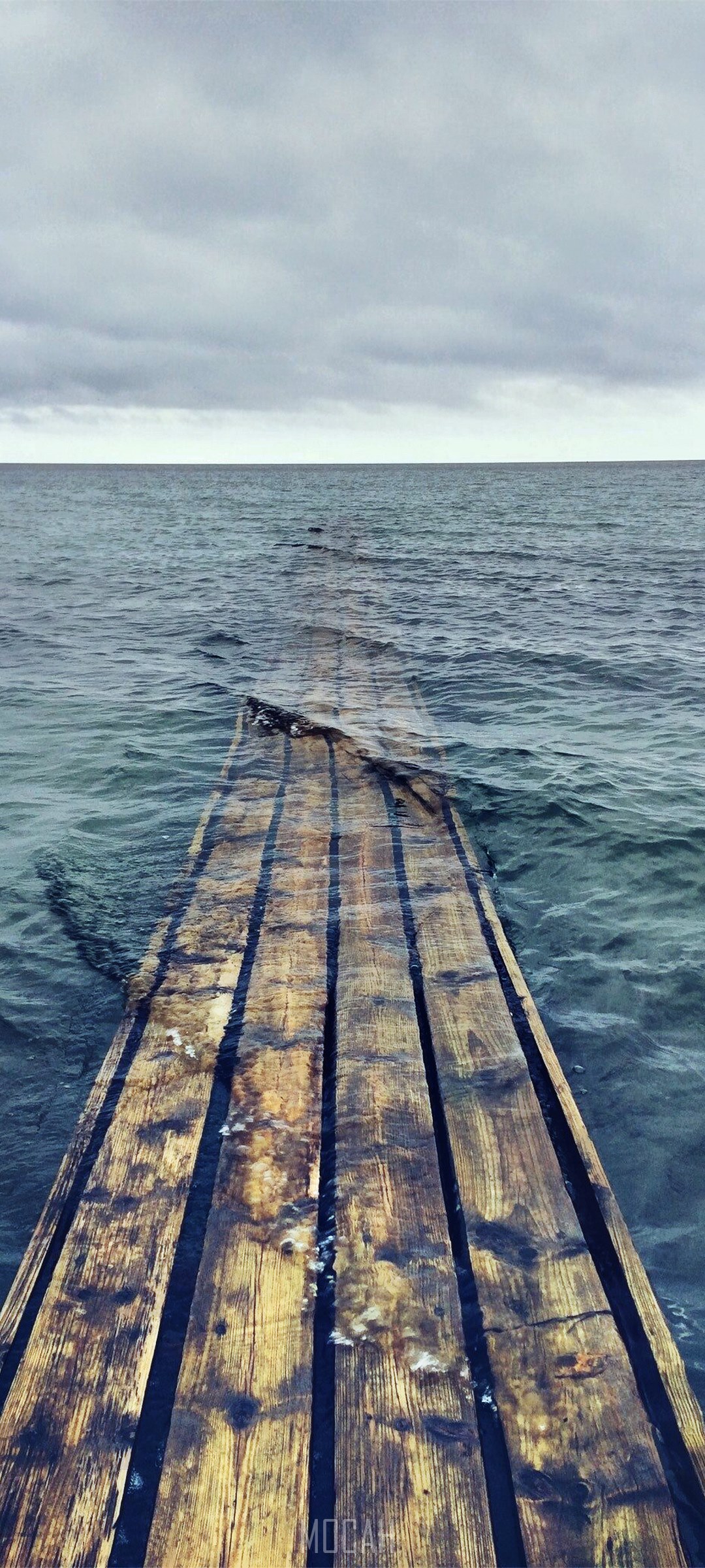 Wooden pier extending into the sea under a cloudy sky HD Phone Wallpaper