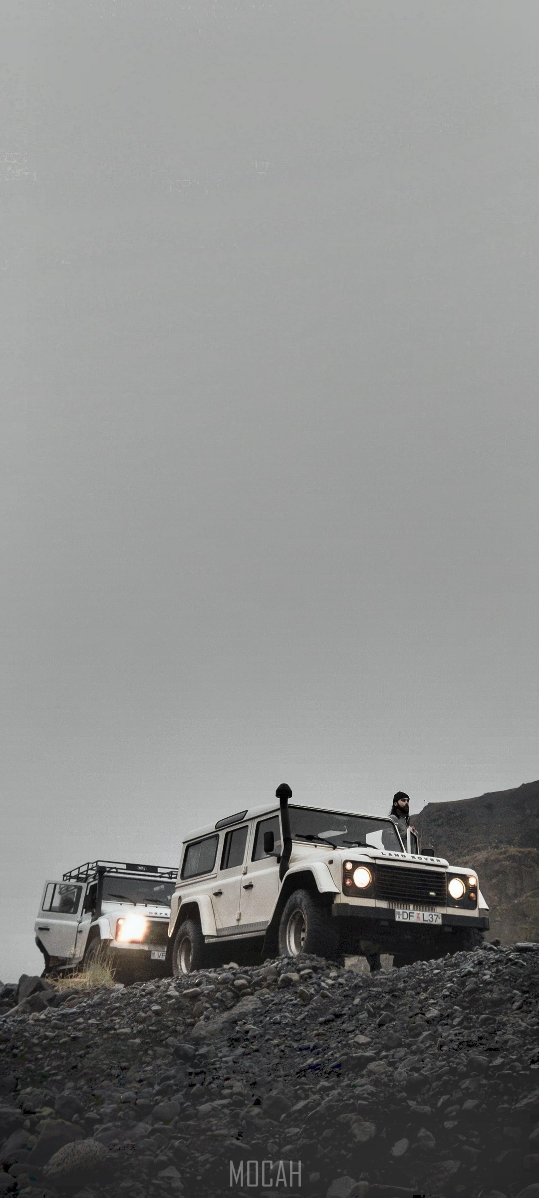 Two Land Rover Defenders on a rocky terrain in Iceland HD Phone Wallpaper