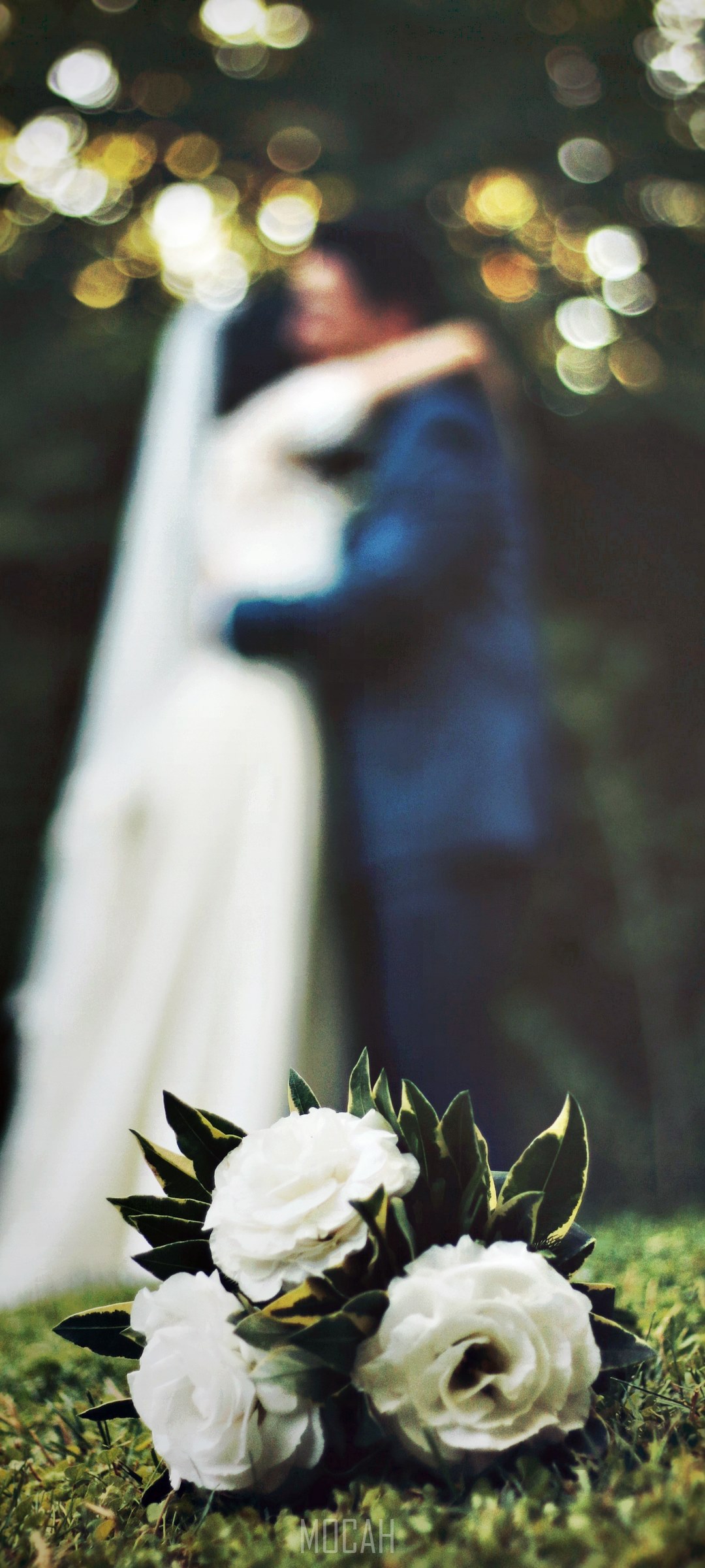 Wedding couple embracing with bouquet in foreground HD Phone Wallpaper
