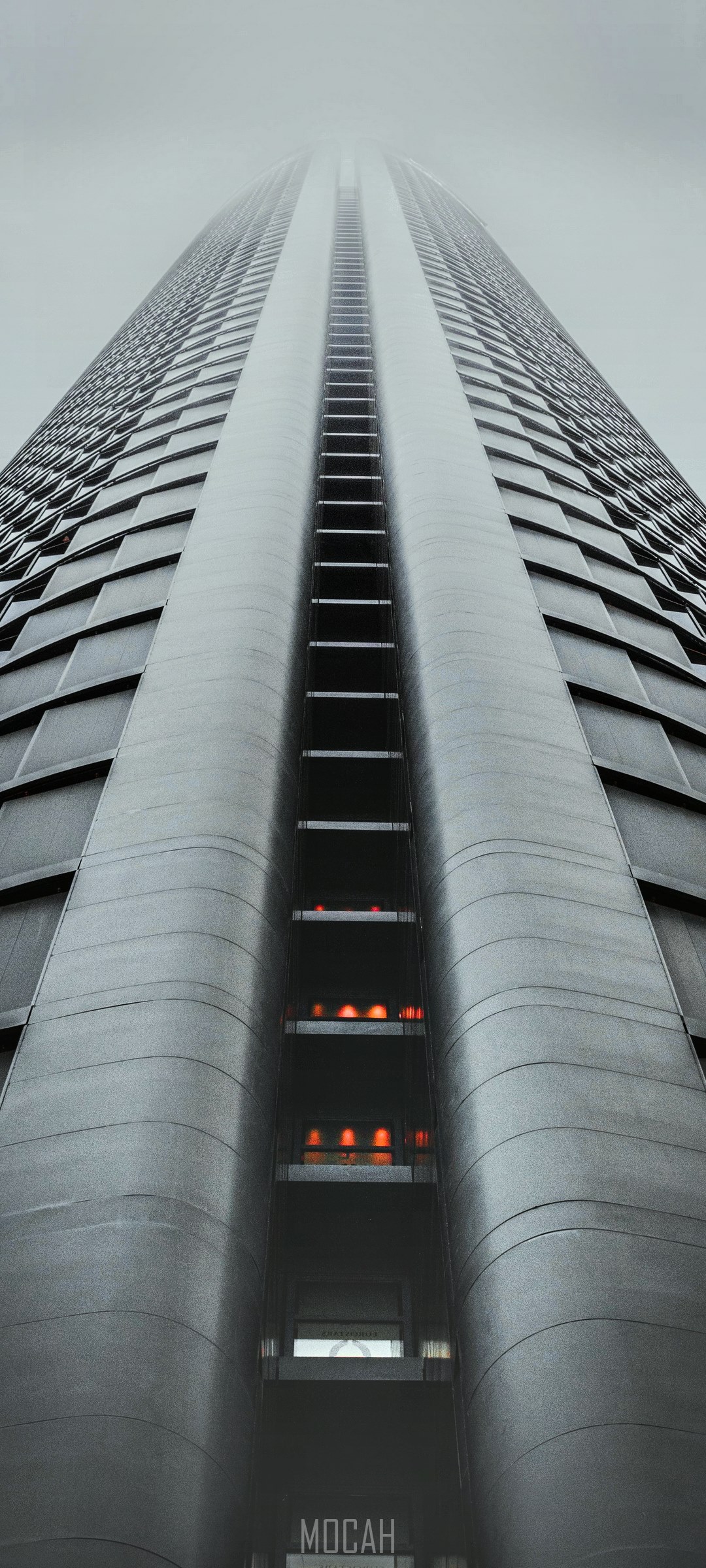 Modern skyscraper with glowing windows in fog HD Phone Wallpaper