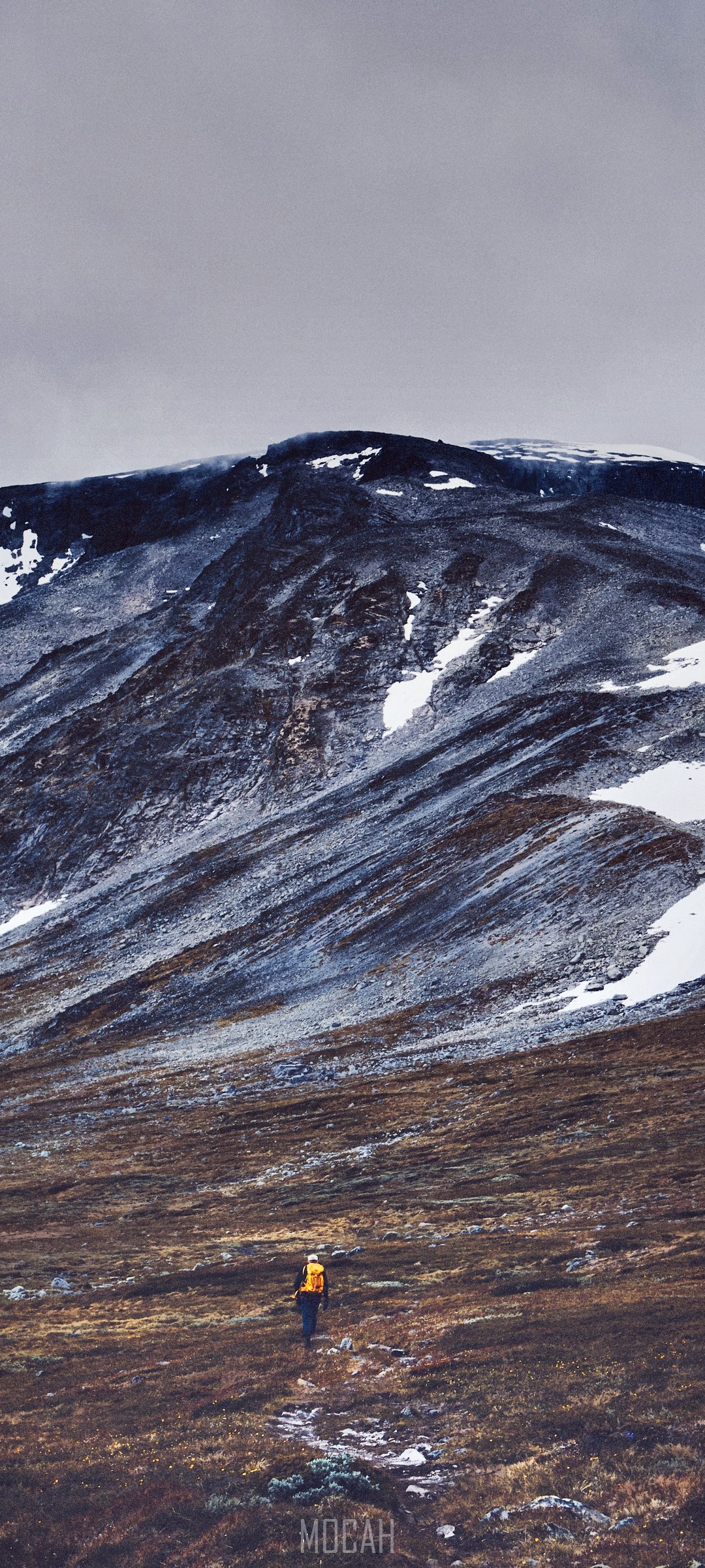 Person hiking on a mountain ridge with snow HD Phone Wallpaper