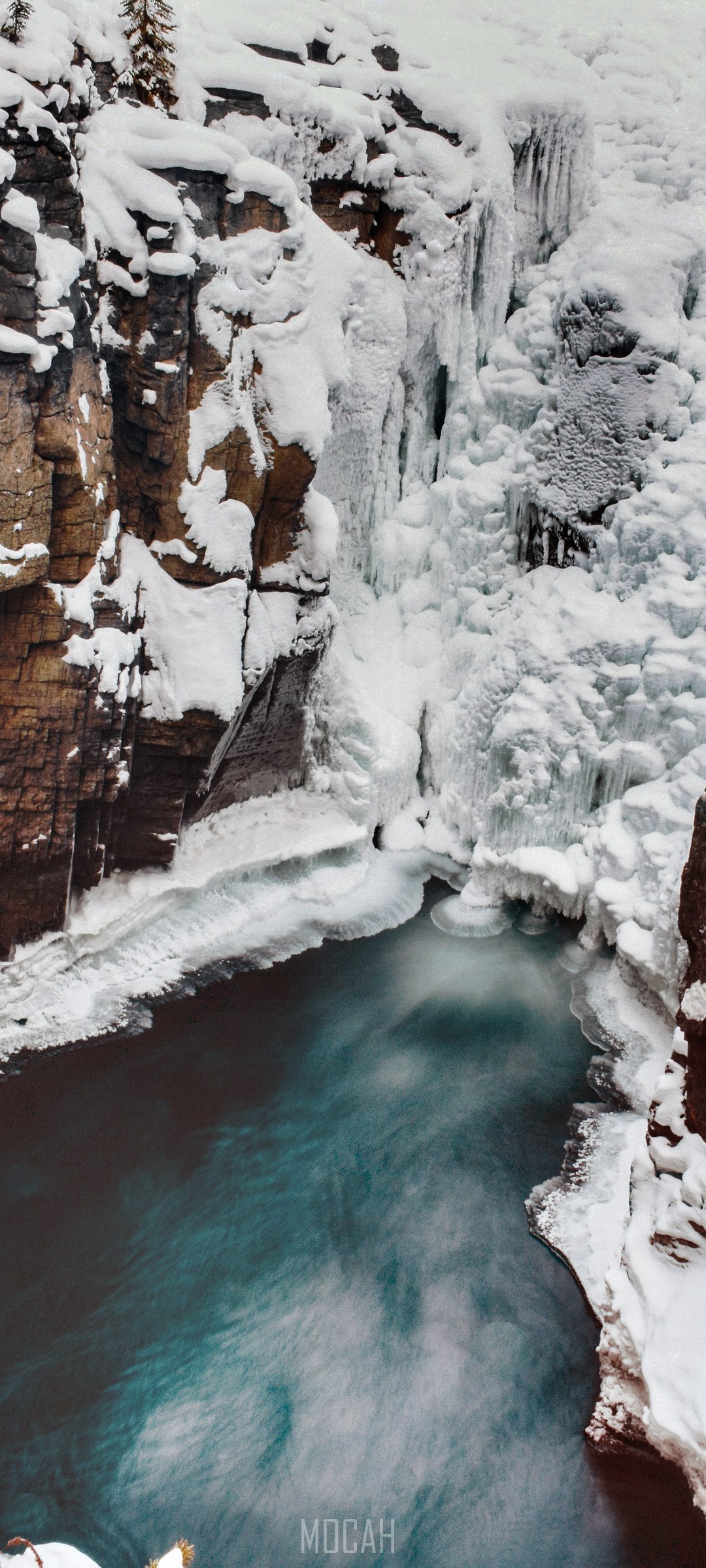 Frozen waterfall and river between snowy cliffs HD Phone Wallpaper