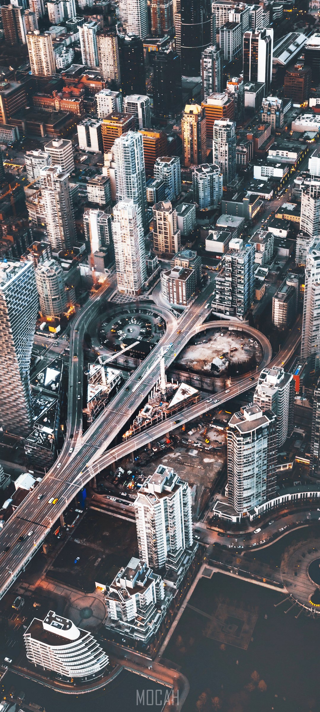 Aerial view of a complex highway interchange in a dense metropolis HD Phone Wallpaper