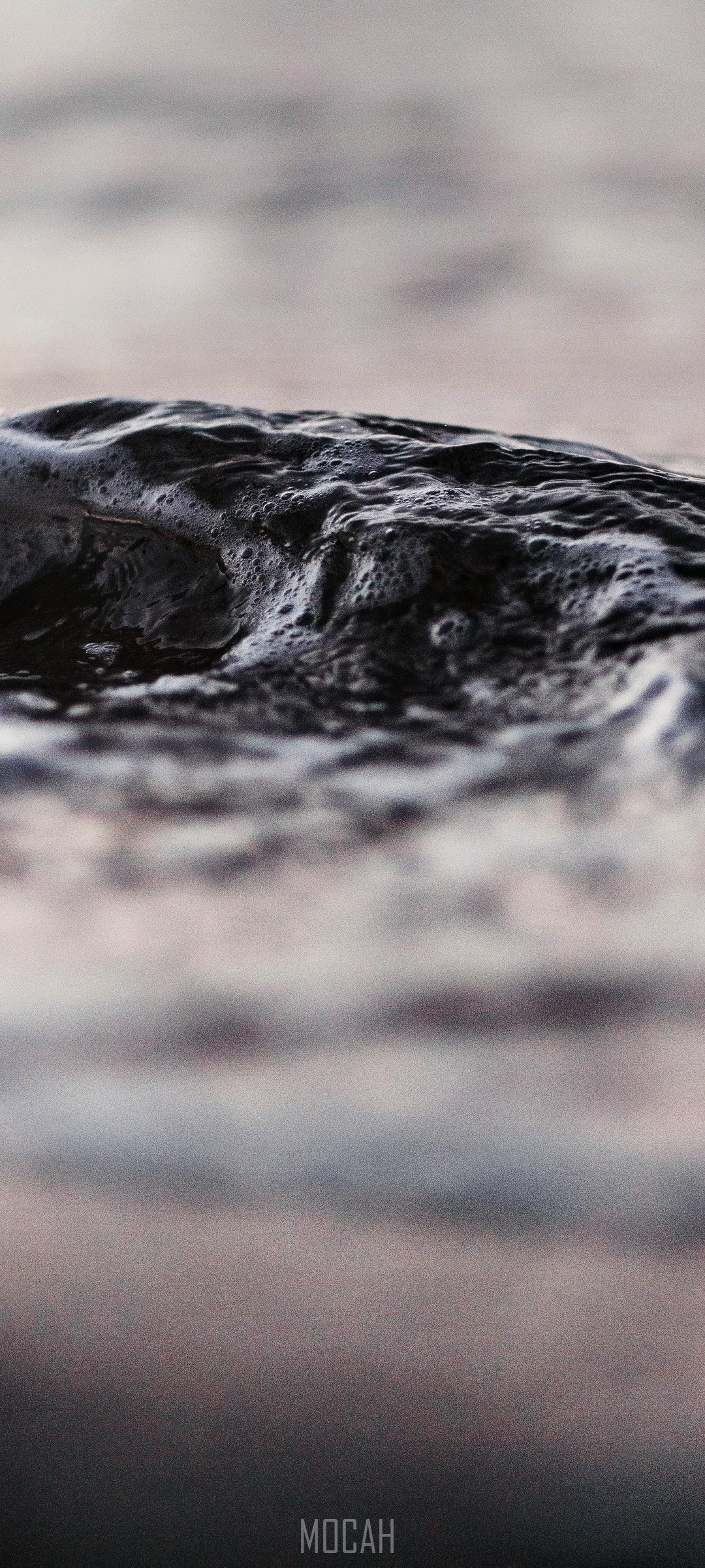 Close-up of dark, wet rock with foam HD Phone Wallpaper