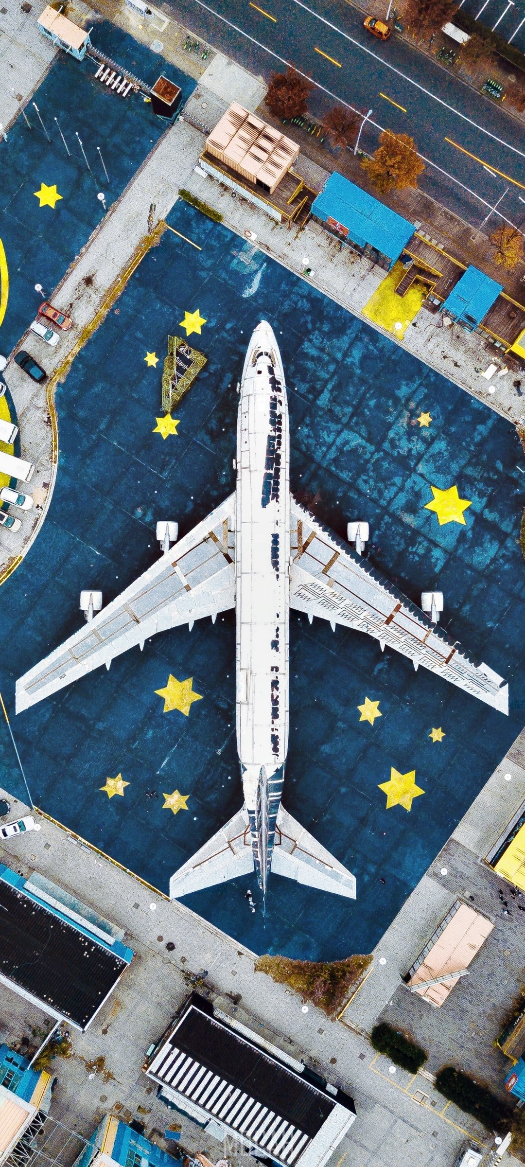 Airplane on a dark blue surface with yellow stars HD Phone Wallpaper