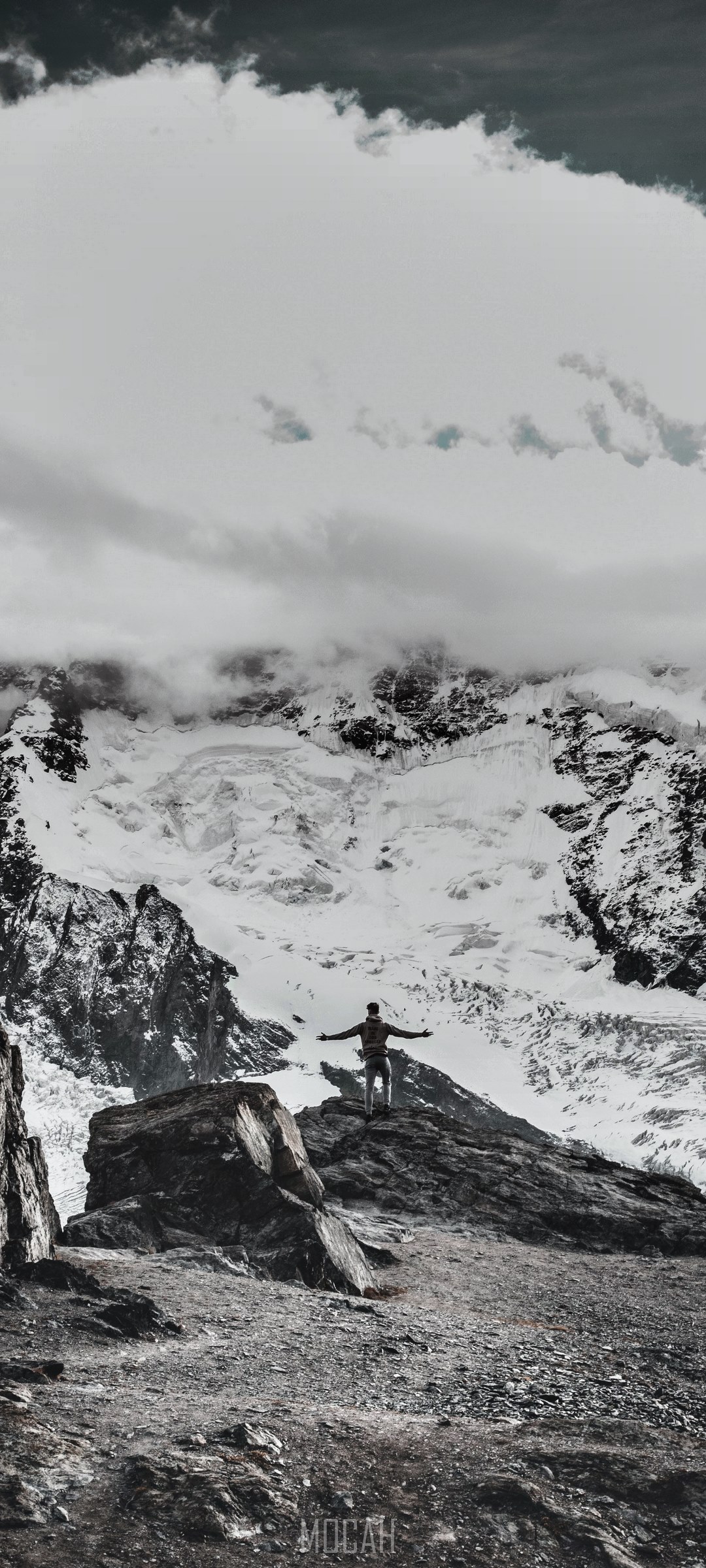 Man on mountain peak with snowy mountains and clouds HD Phone Wallpaper