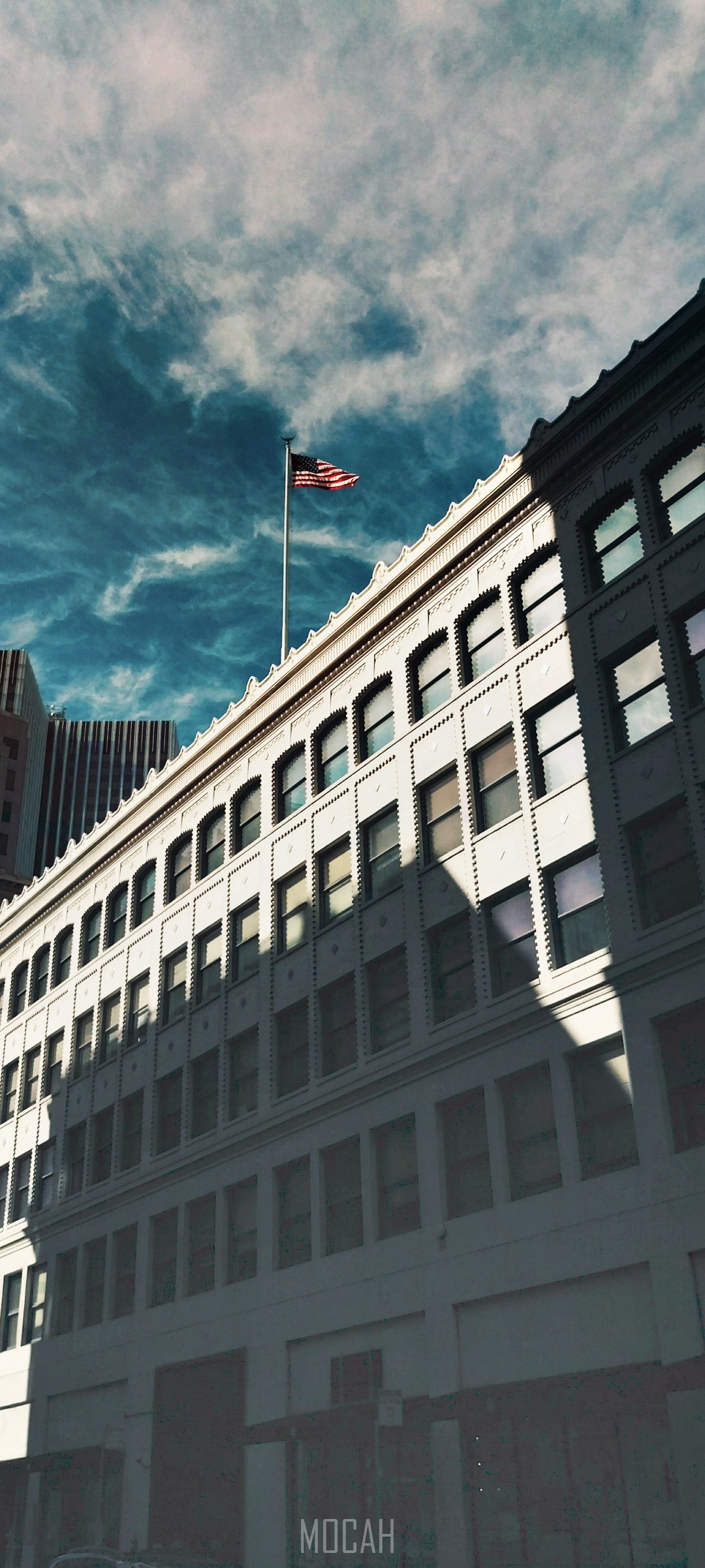 American flag on building facade with dramatic clouds HD Phone Wallpaper