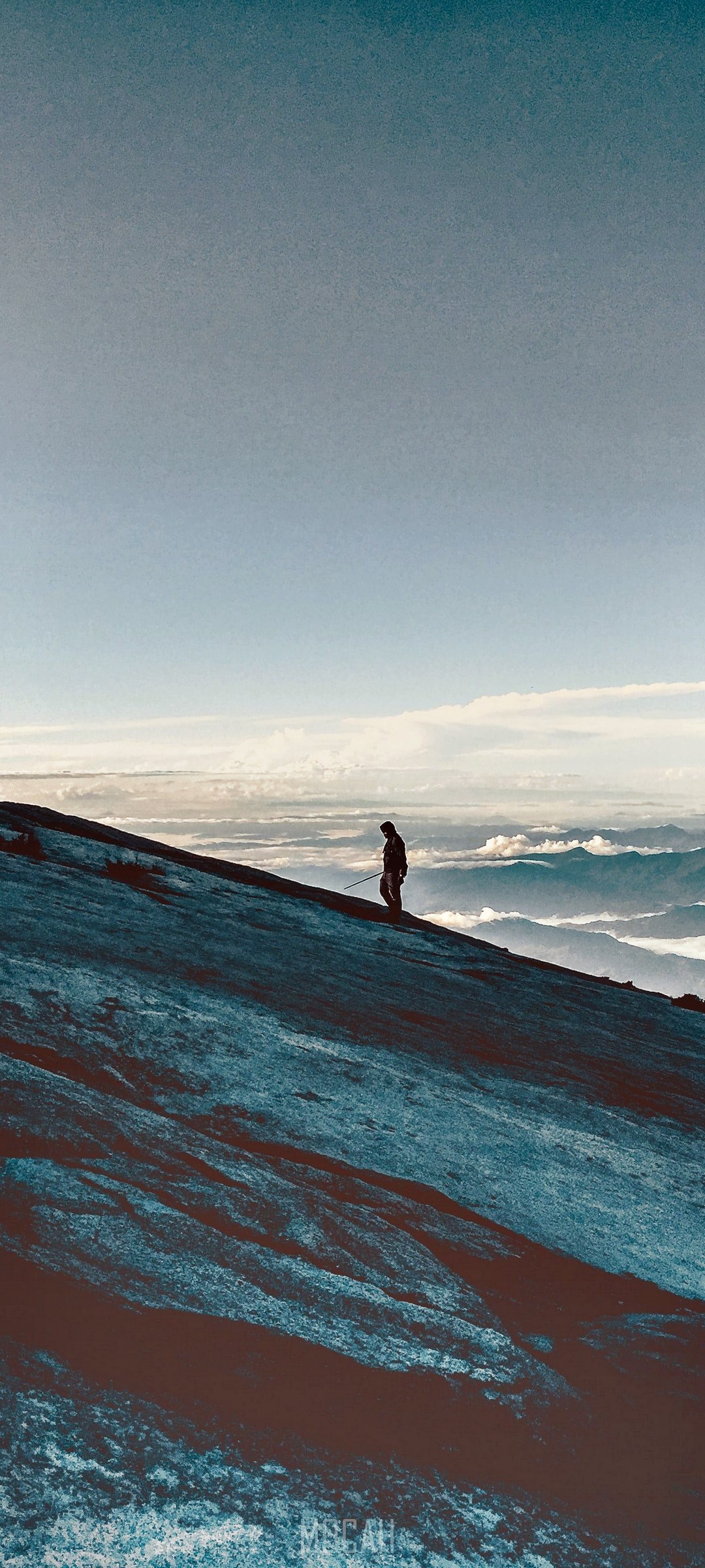 Person walking on a mountain slope HD Phone Wallpaper