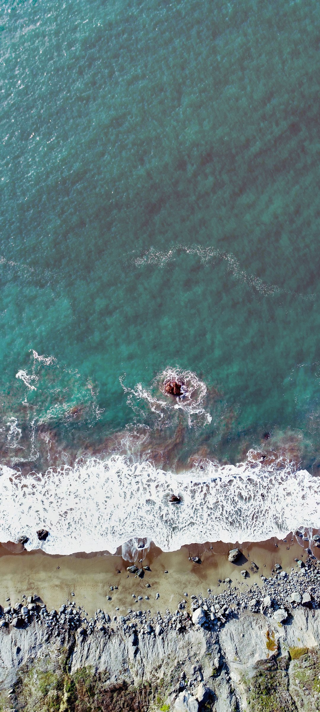 Aerial view of waves crashing on a rocky beach HD Phone Wallpaper