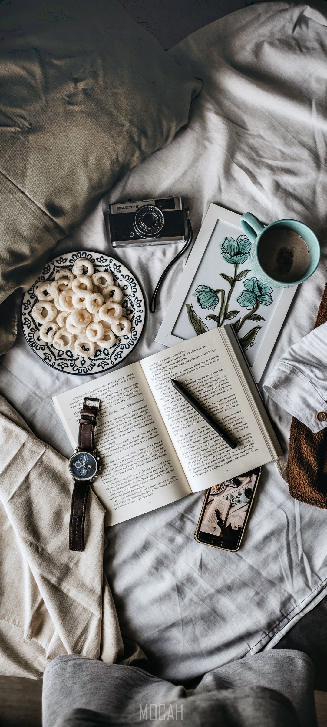 Overhead view of a bed with a book, camera, and coffee HD Phone Wallpaper