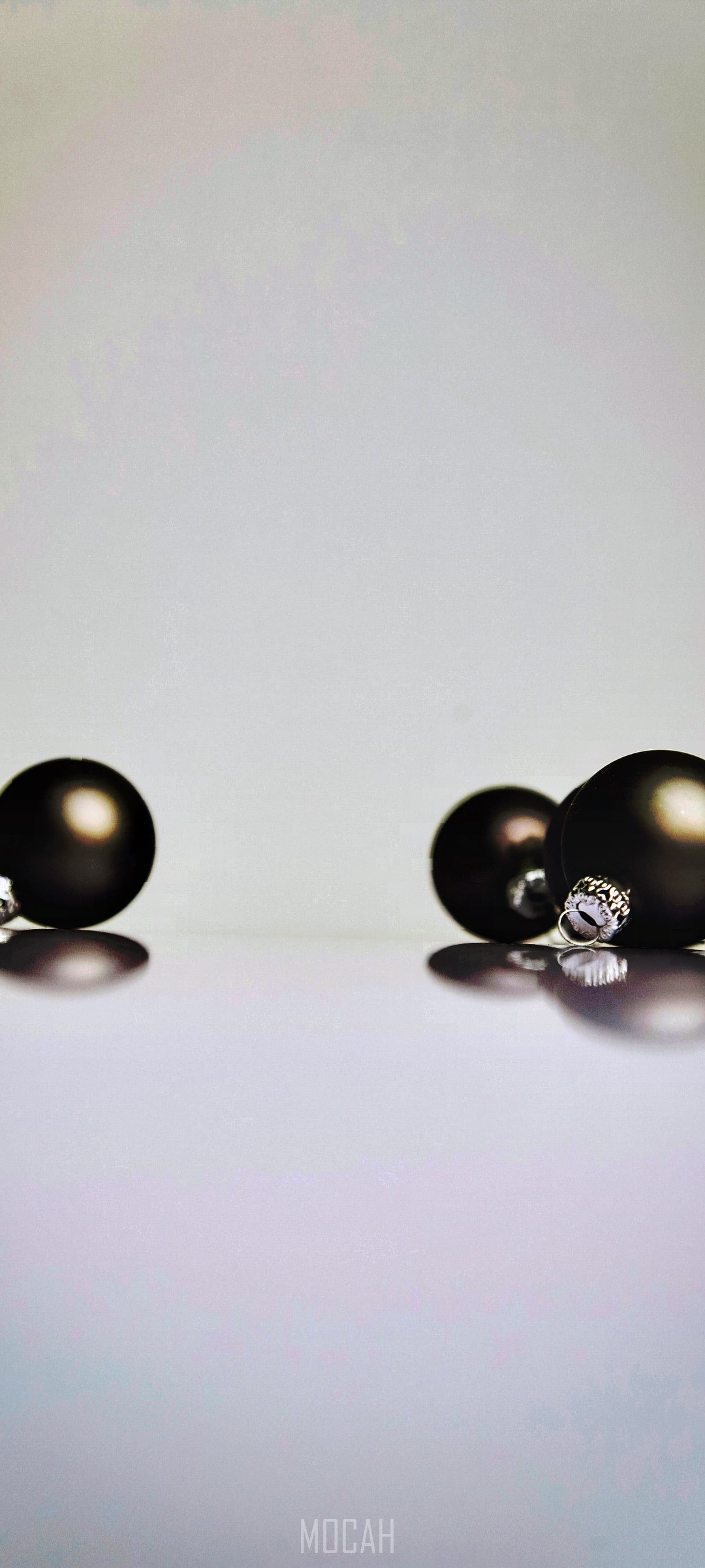 Four dark Christmas ornaments on a reflective surface HD Phone Wallpaper