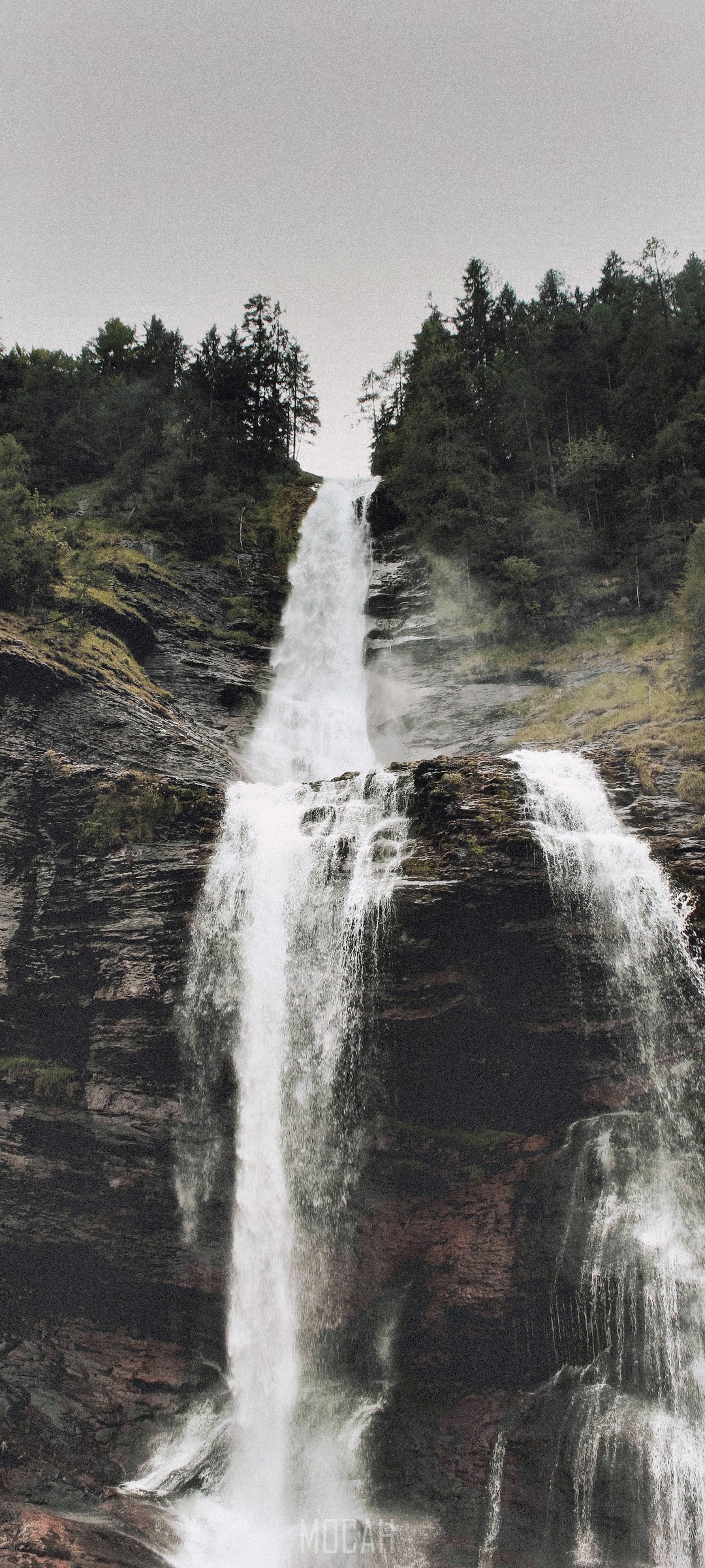 Waterfall cascading down a rocky cliff face HD Phone Wallpaper